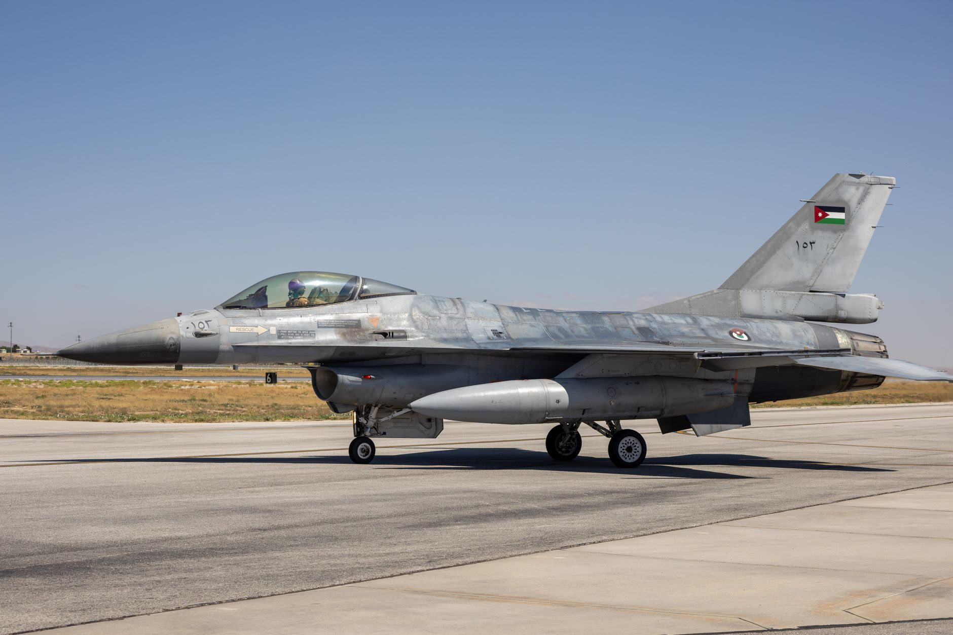rows of Air National Guard fighter aircraft parked on a tarmac at a domestic military airfield, maintenance equipment visible nearby
