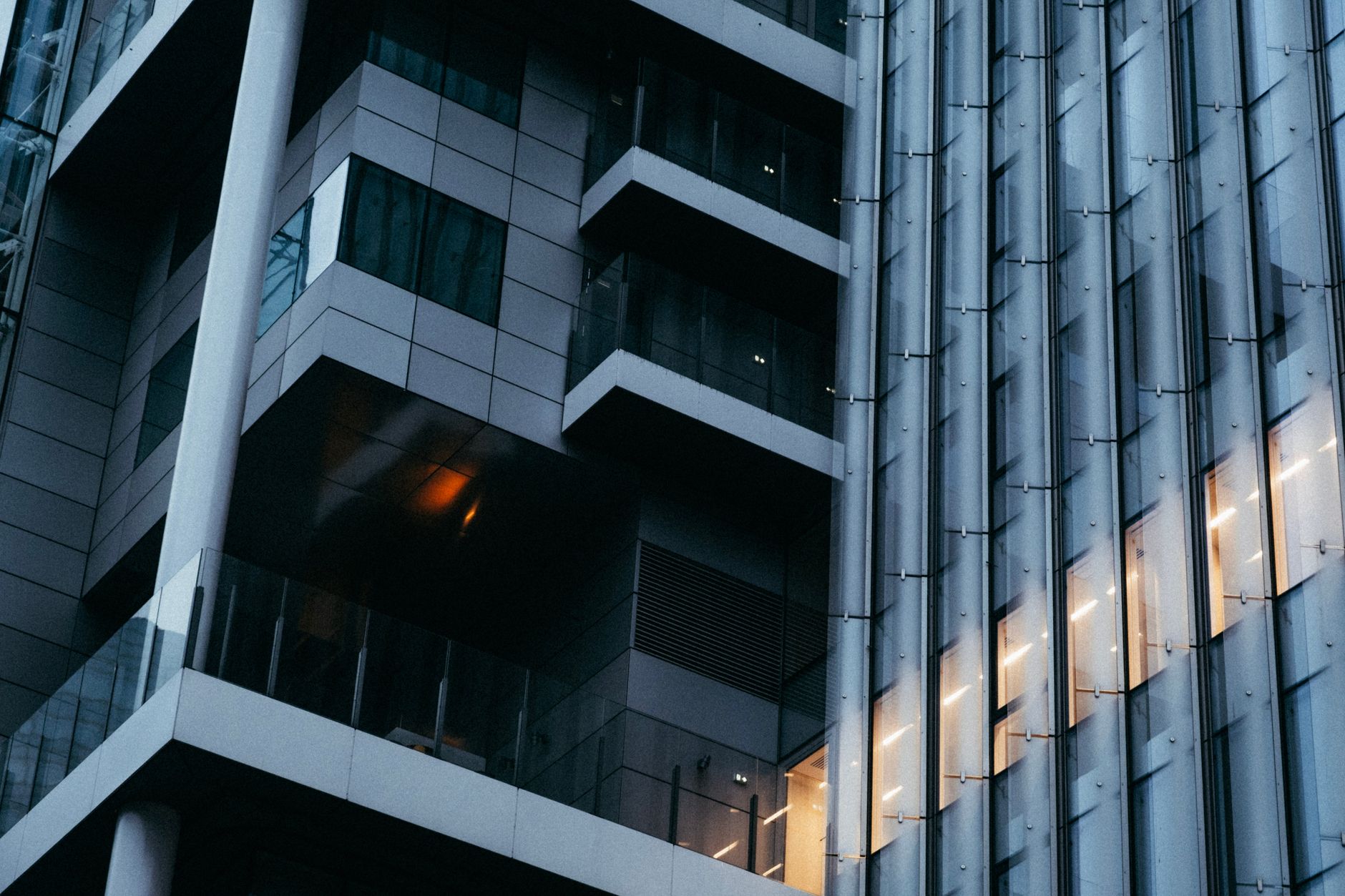 a modern AI research campus exterior at dusk, glass-and-steel buildings reflecting ambient light, no signage visible