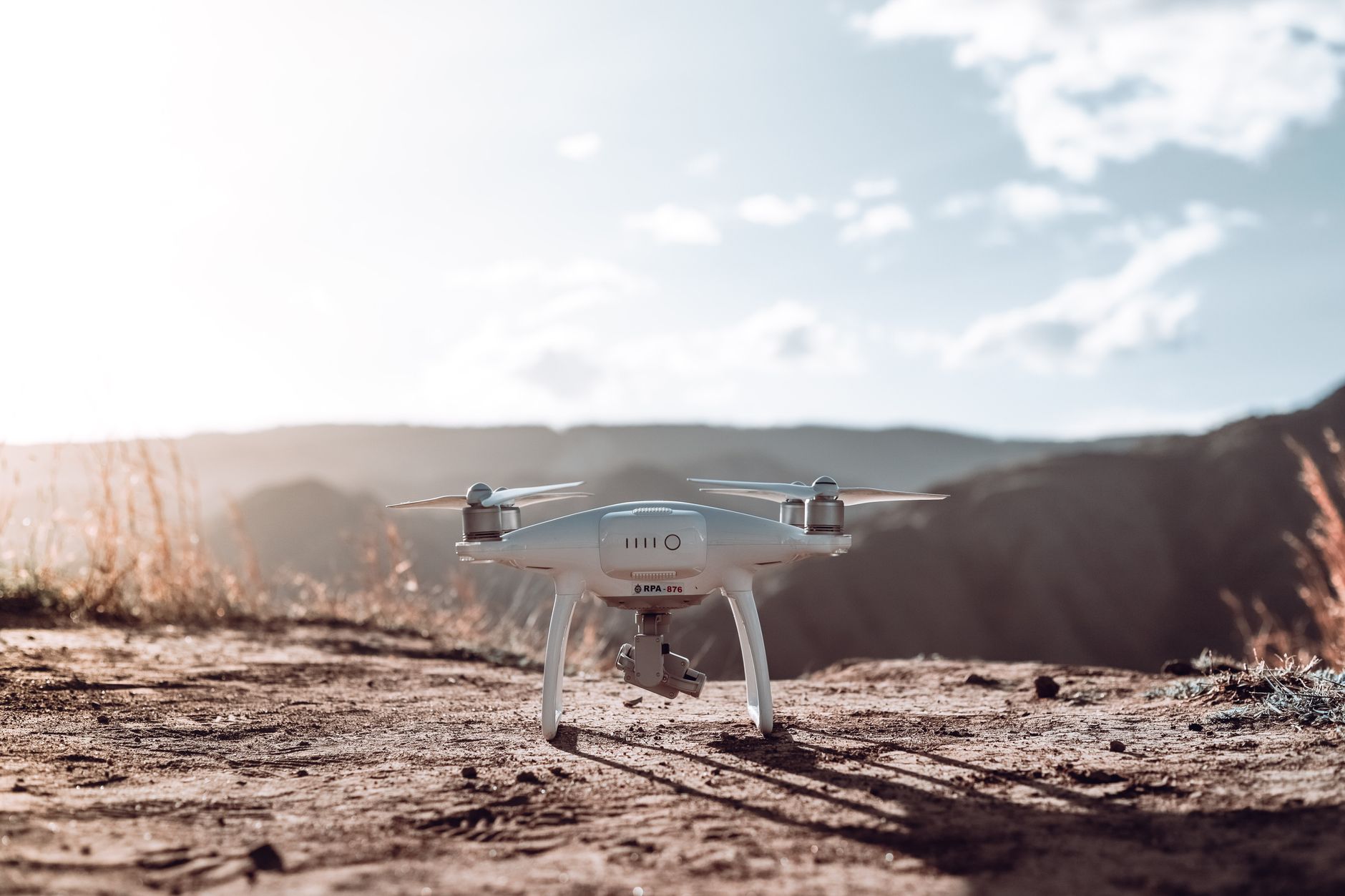 a portable counter-drone radar and sensor array set up on open desert terrain near a vehicle staging area, late afternoon light casting long shadows across the equipment