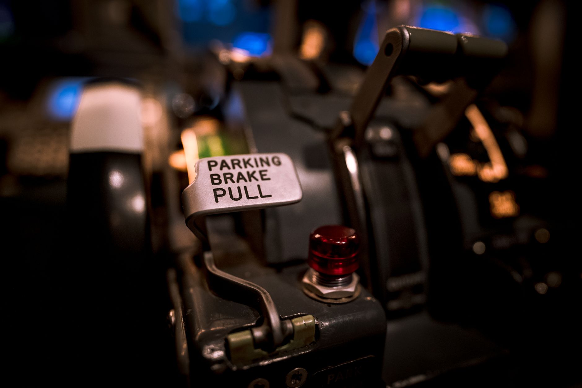 a close-up of a rocket-propelled ejection seat mounted in an aircraft cockpit on a production floor, viewed from the side with assembly equipment visible in the background