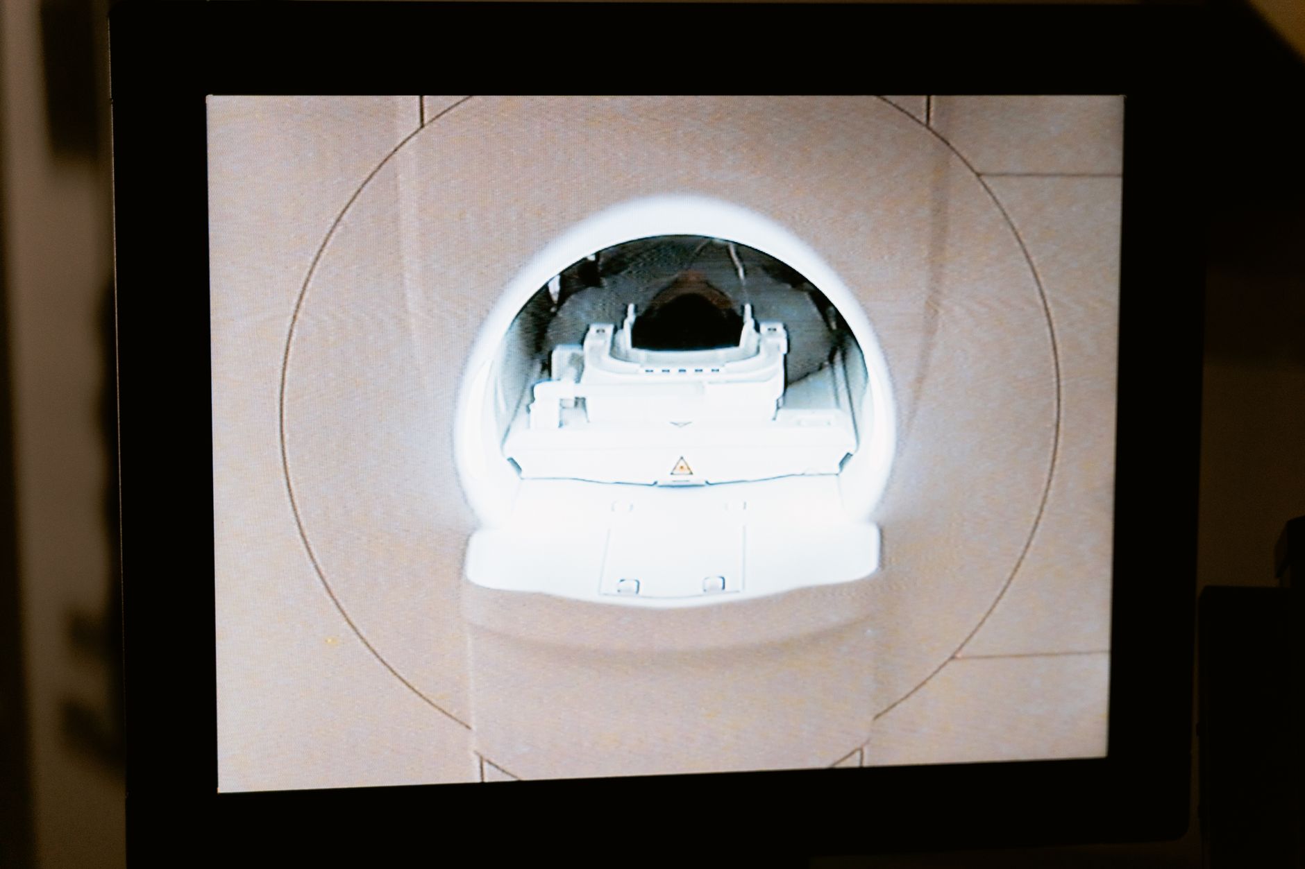 a modern neuroimaging suite with an MRI machine and adjacent workstation displays showing brain scan data, no people visible