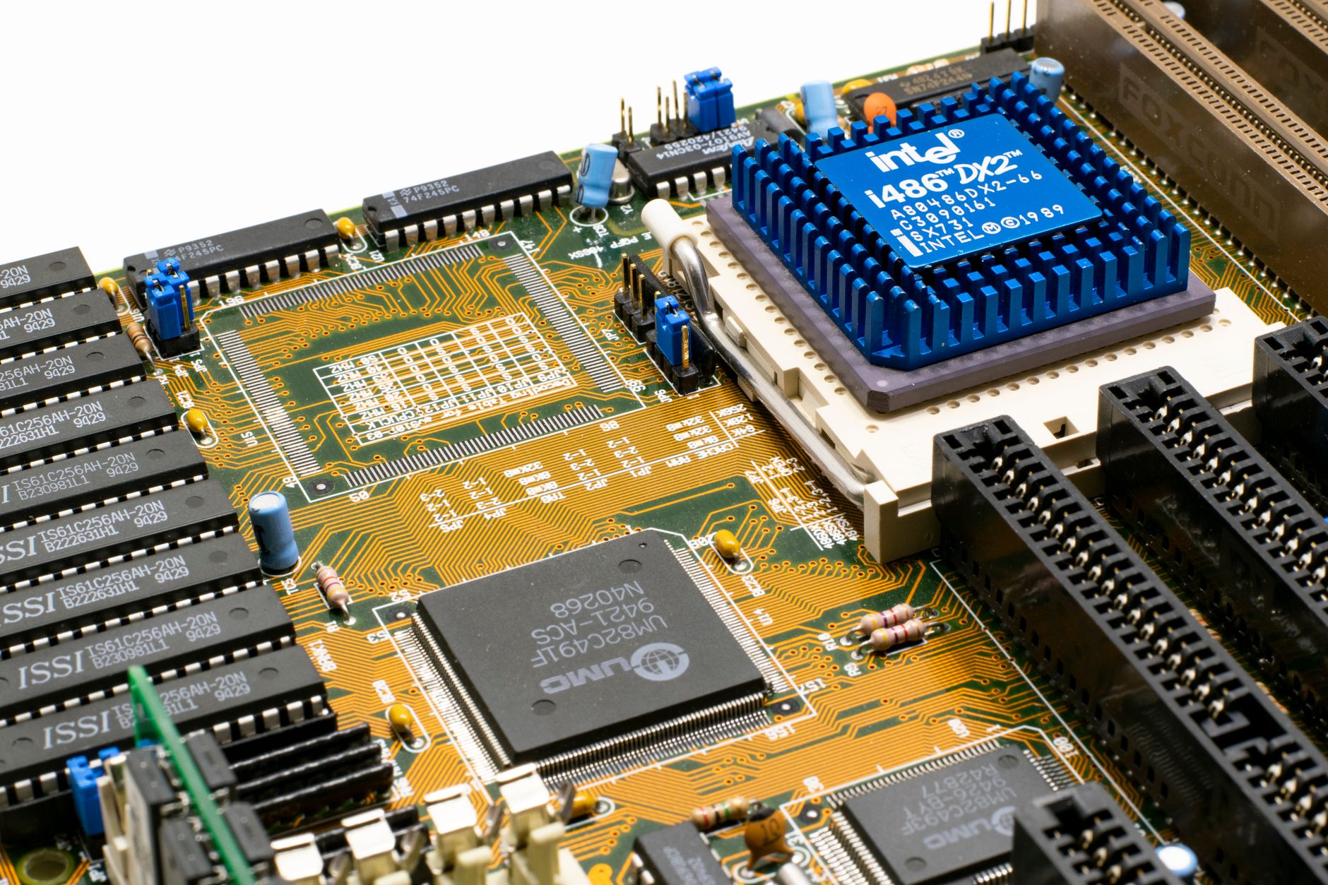 an engineering workstation in a semiconductor design lab displaying chip architecture diagrams on multiple monitors, with circuit boards visible in the background