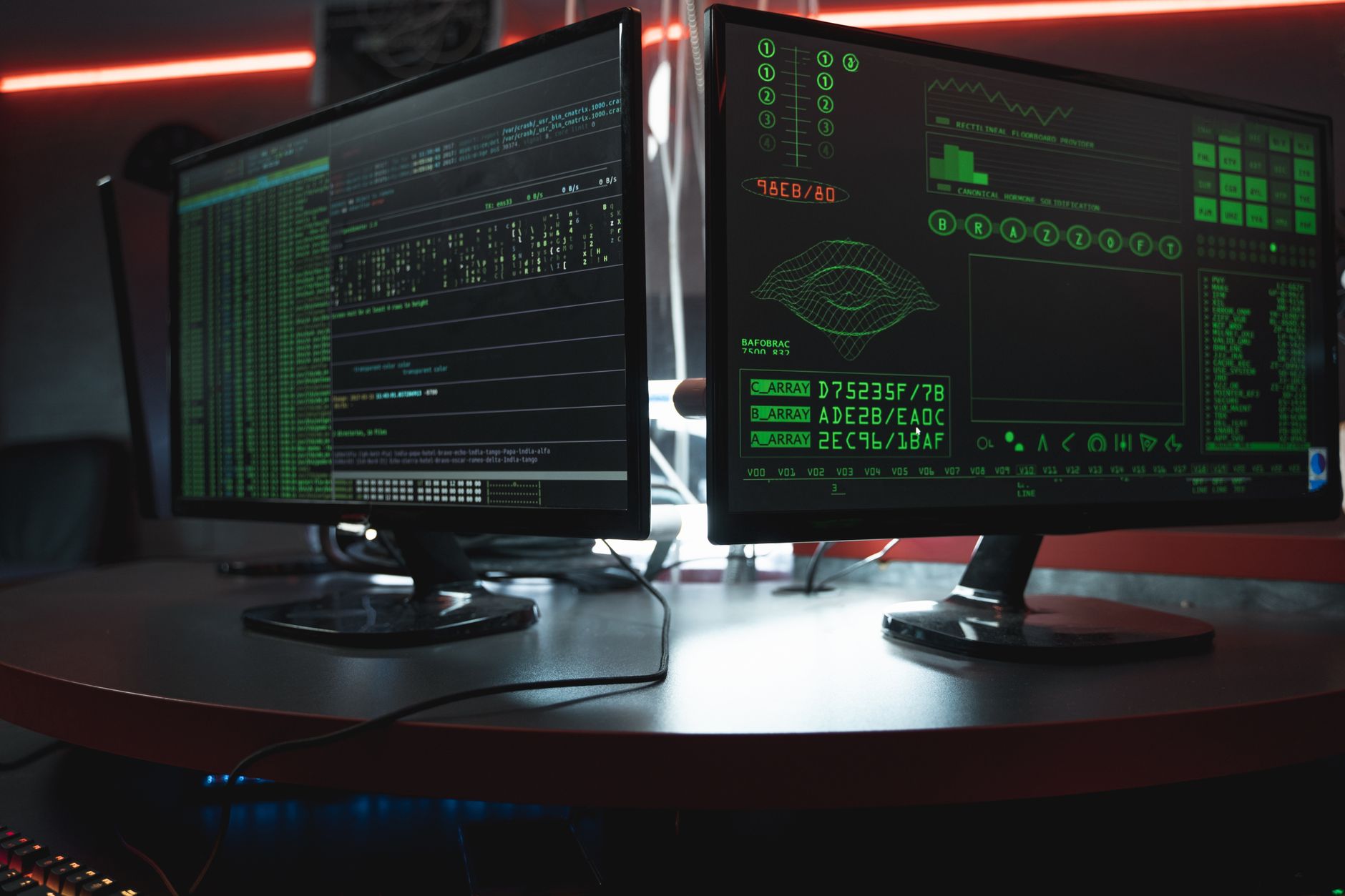 a modern open-plan software engineering office with multiple large monitors displaying code and network visualization dashboards, workstations in the foreground and glass-walled conference rooms in the background