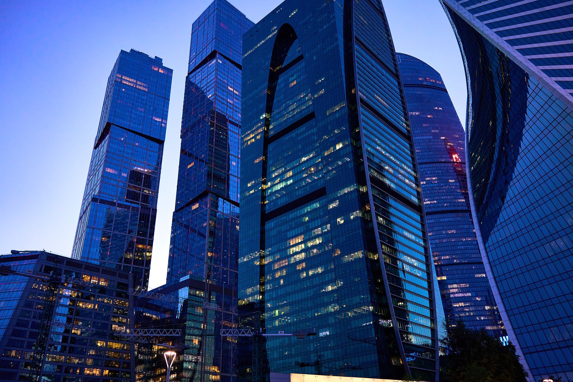 a modern data center facility exterior at dusk, server cooling units visible along the building facade, surrounded by urban infrastructure