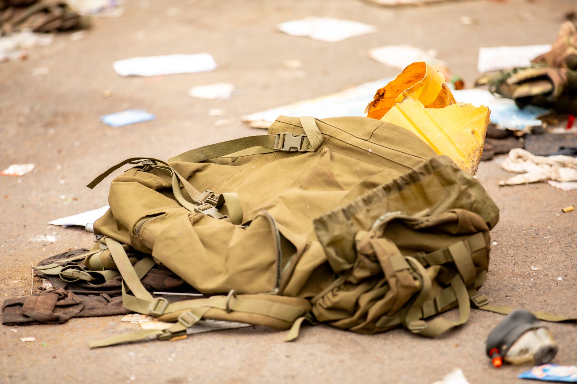 rows of neatly arranged personal gear and duffel bags in a large institutional common area, suggesting a temporary military staging space inside a civic building, no people as focal point