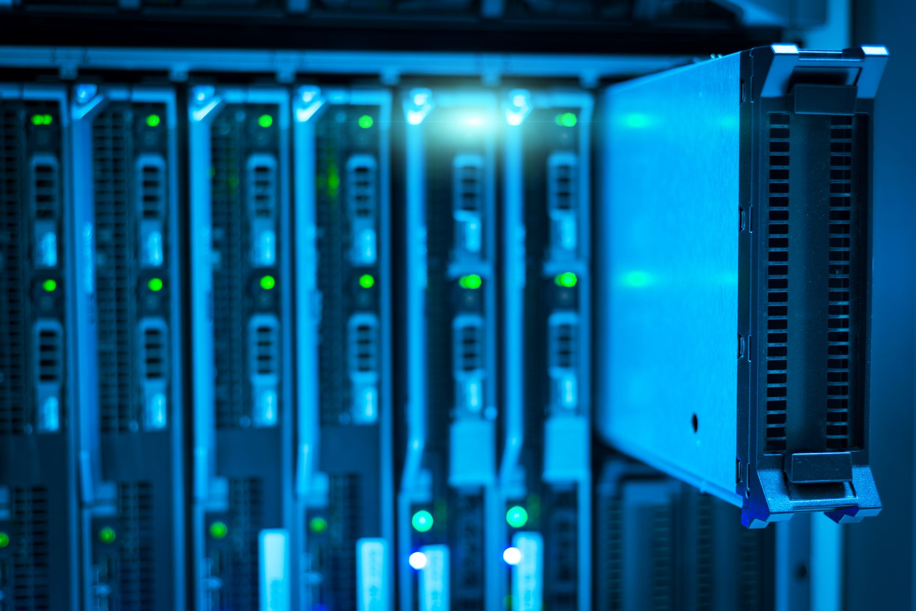 rows of server racks inside a large climate-controlled data center facility, with cable management systems and indicator lights visible along the corridor