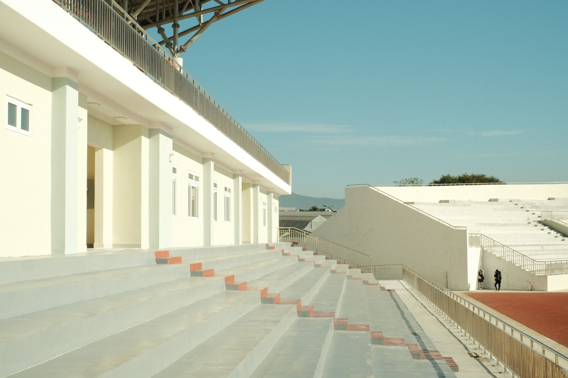 wide-angle view of a Marine Corps recruit depot parade deck and training barracks complex in the early morning, no personnel visible, administrative buildings in background