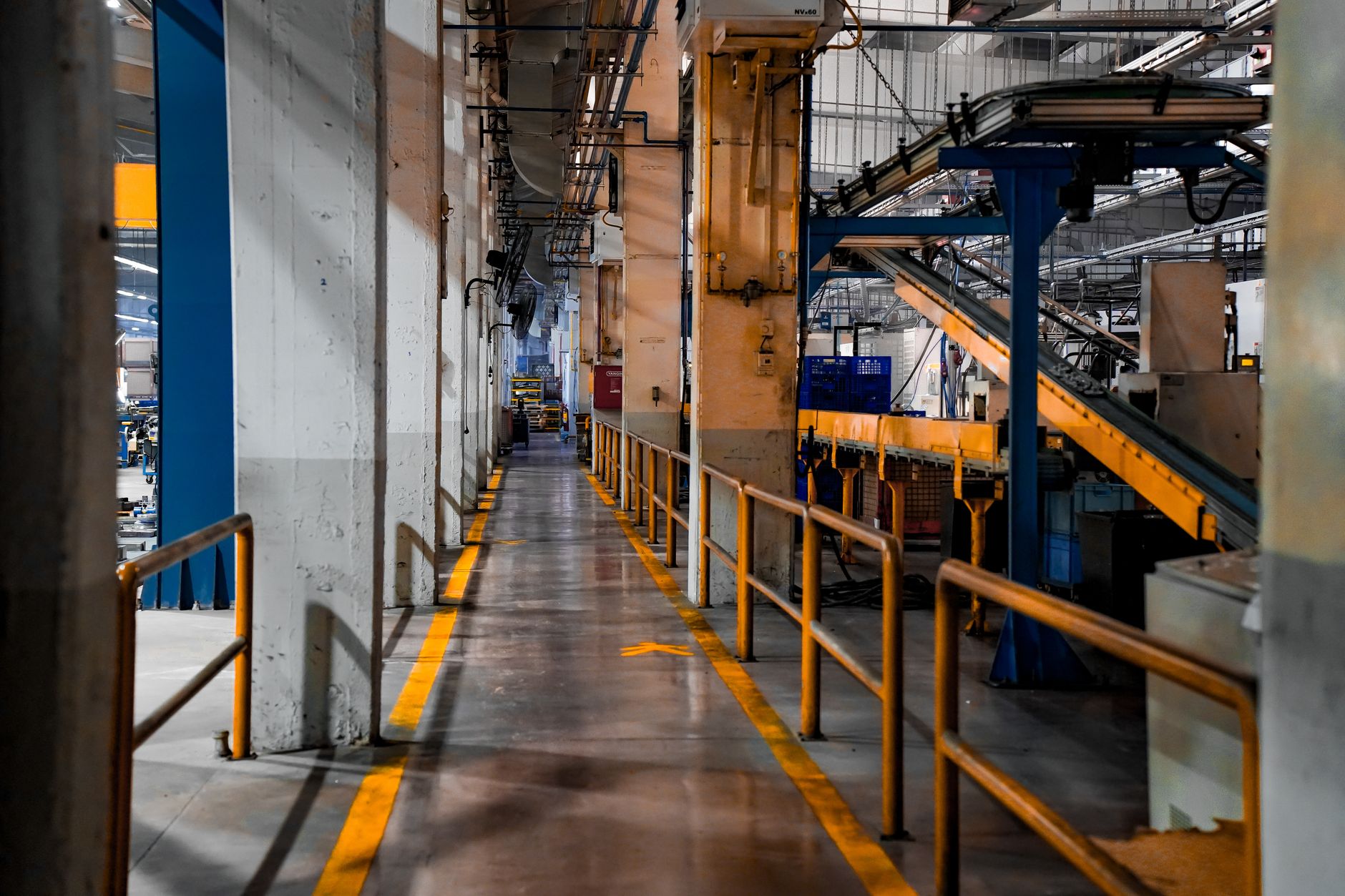 rows of Patriot PAC-3 missile canisters aligned inside a large defense manufacturing facility, machinery visible along the production floor