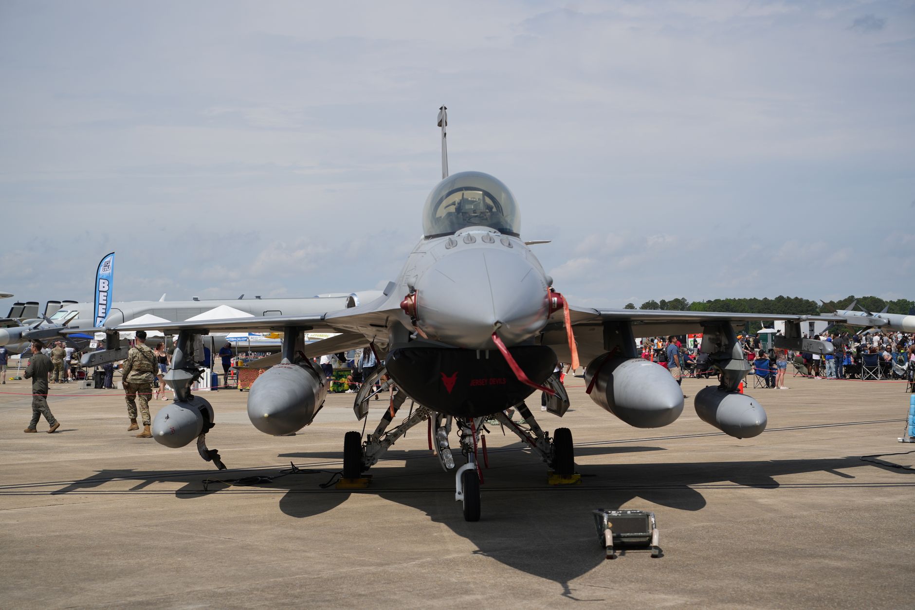 a mobile surface-to-air missile launcher vehicle with vertical launch canisters, parked on an open airfield during a static display