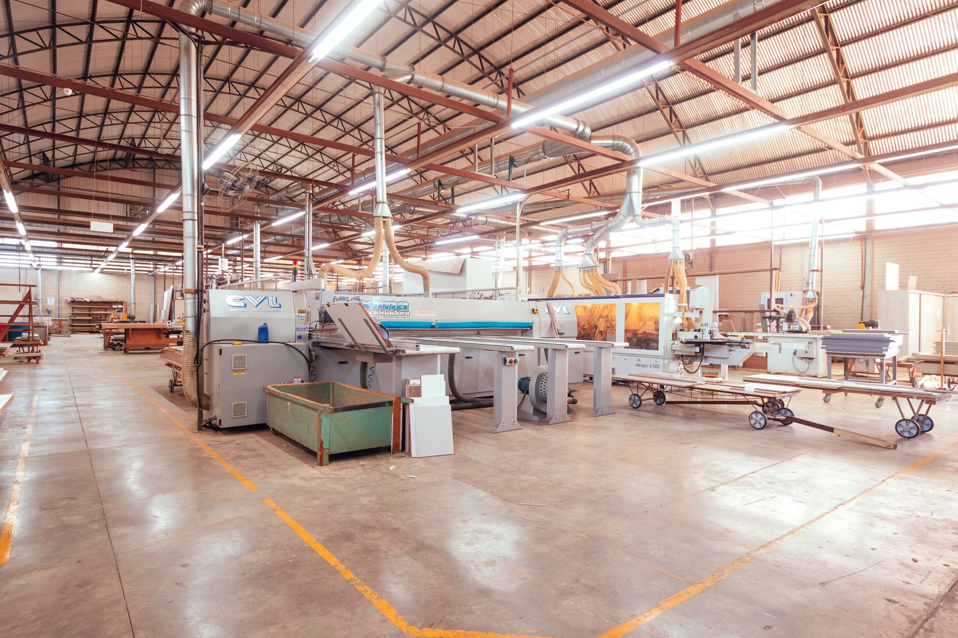 rows of missile assembly fixtures inside a large, high-bay defense manufacturing facility, lit by overhead fluorescent lighting
