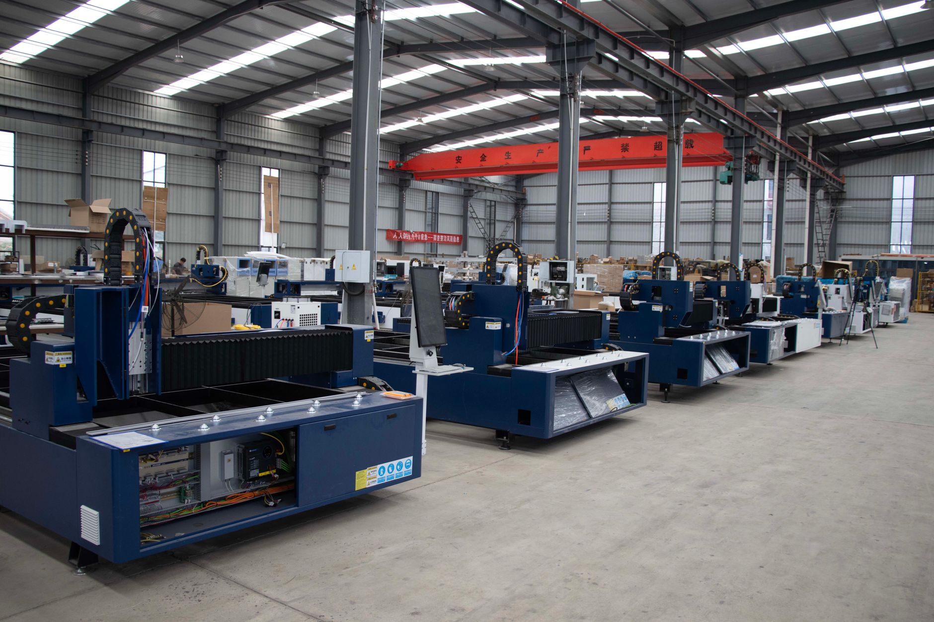 interior of a large aircraft manufacturing facility with fighter jet fuselages in various stages of assembly on a production floor