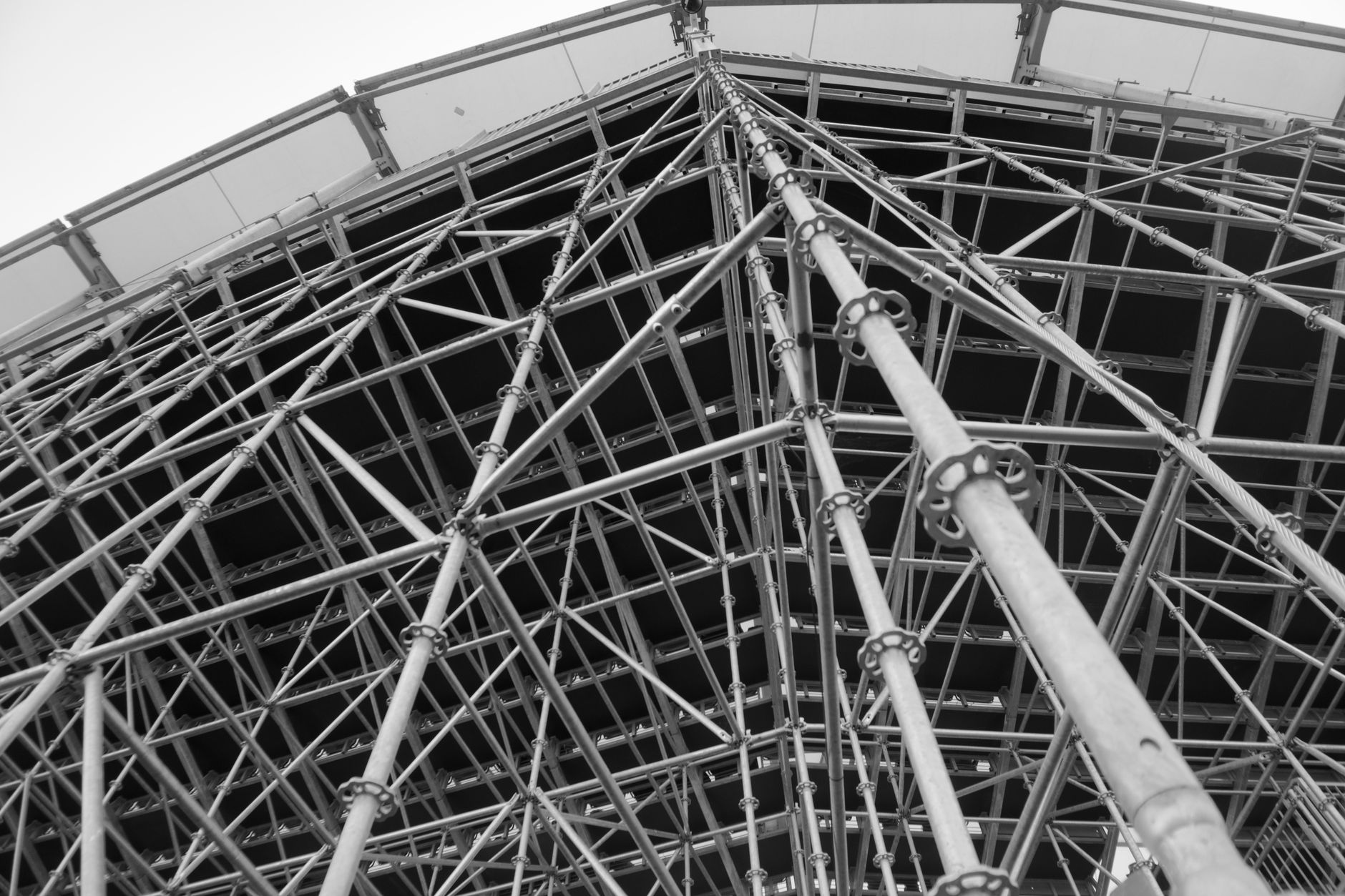 a Nimitz-class aircraft carrier in a dry dock undergoing maintenance, surrounded by scaffolding and support equipment
