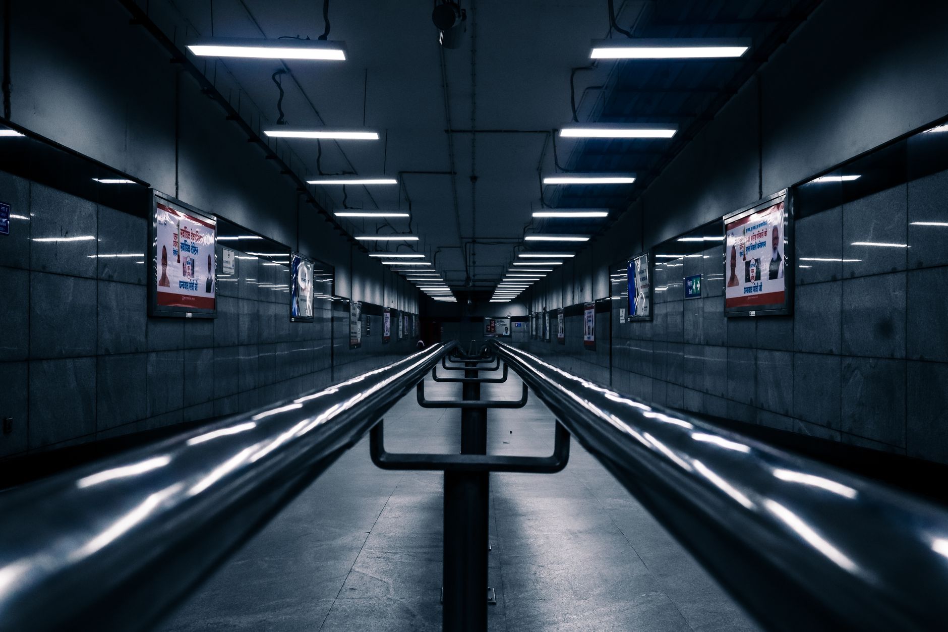 rows of compact loitering munition transport cases staged inside a military logistics facility, fluorescent overhead lighting, no personnel as focal point