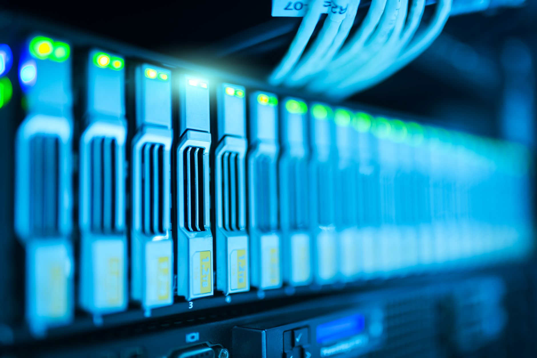 server rack infrastructure inside a secured data center facility, cable bundles visible along the floor, reinforced door in the background