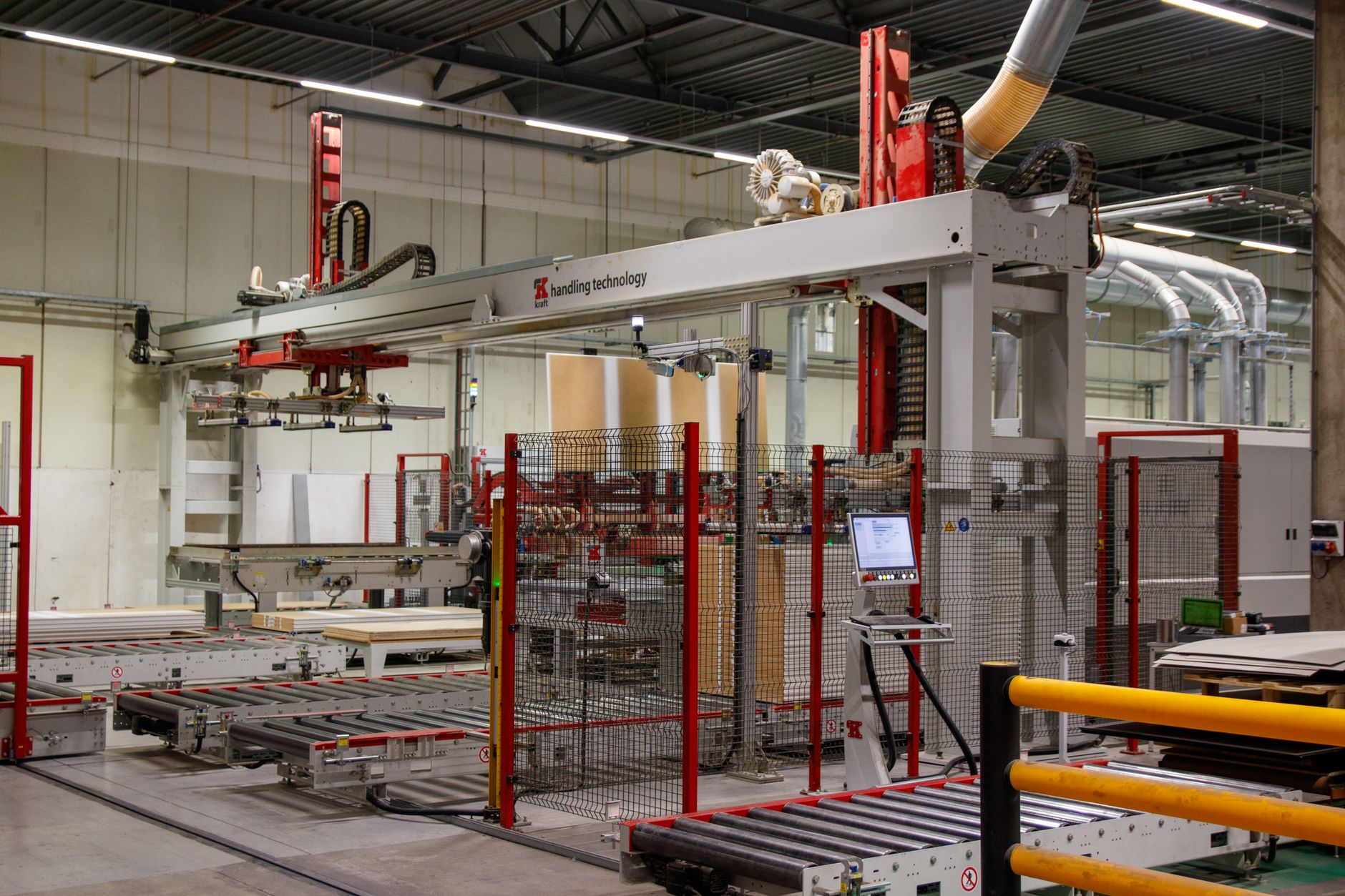 rows of humanoid robot units in various stages of assembly inside a large Chinese manufacturing facility, with overhead lighting and industrial equipment visible throughout
