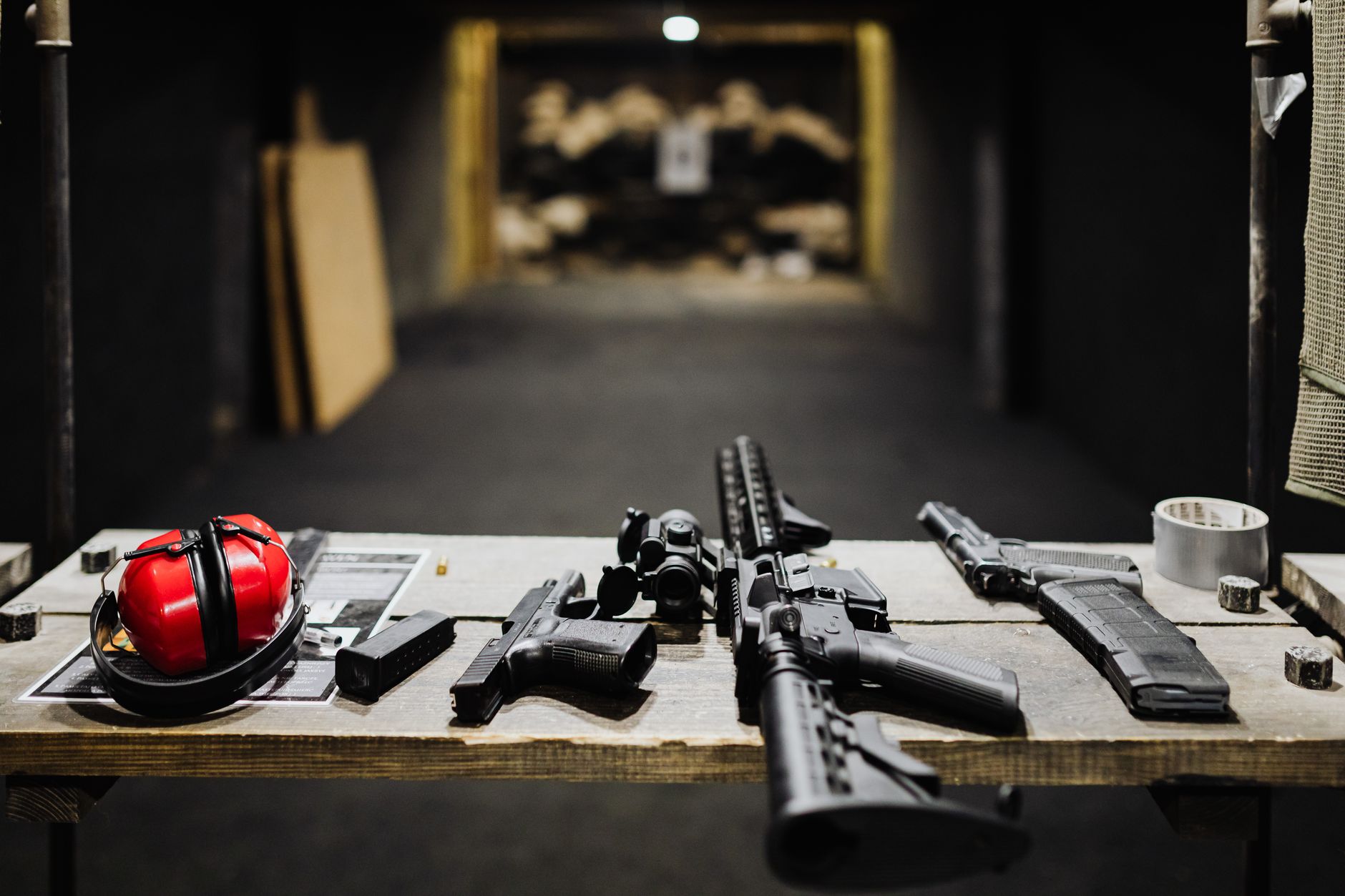 a Marine infantryman's rifle and gear laid out on a field table during an equipment review, no faces visible, dry terrain in the background
