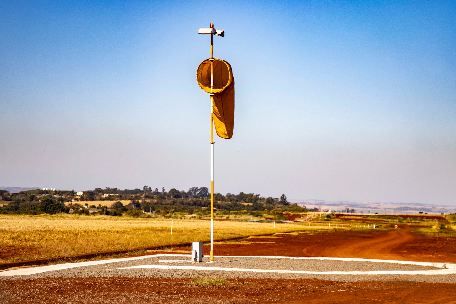 a small loitering munition displayed on a test stand in an outdoor range facility, with scrubland terrain in the background