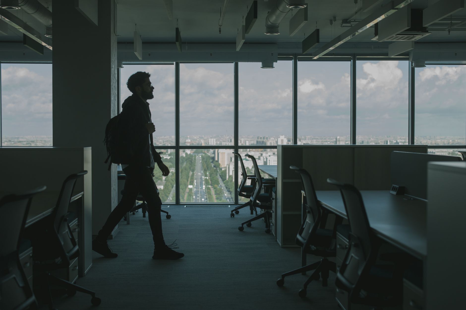 interior of a modern venture capital office with floor-to-ceiling windows overlooking a city skyline, whiteboards visible in background with diagrams, no people as focal point