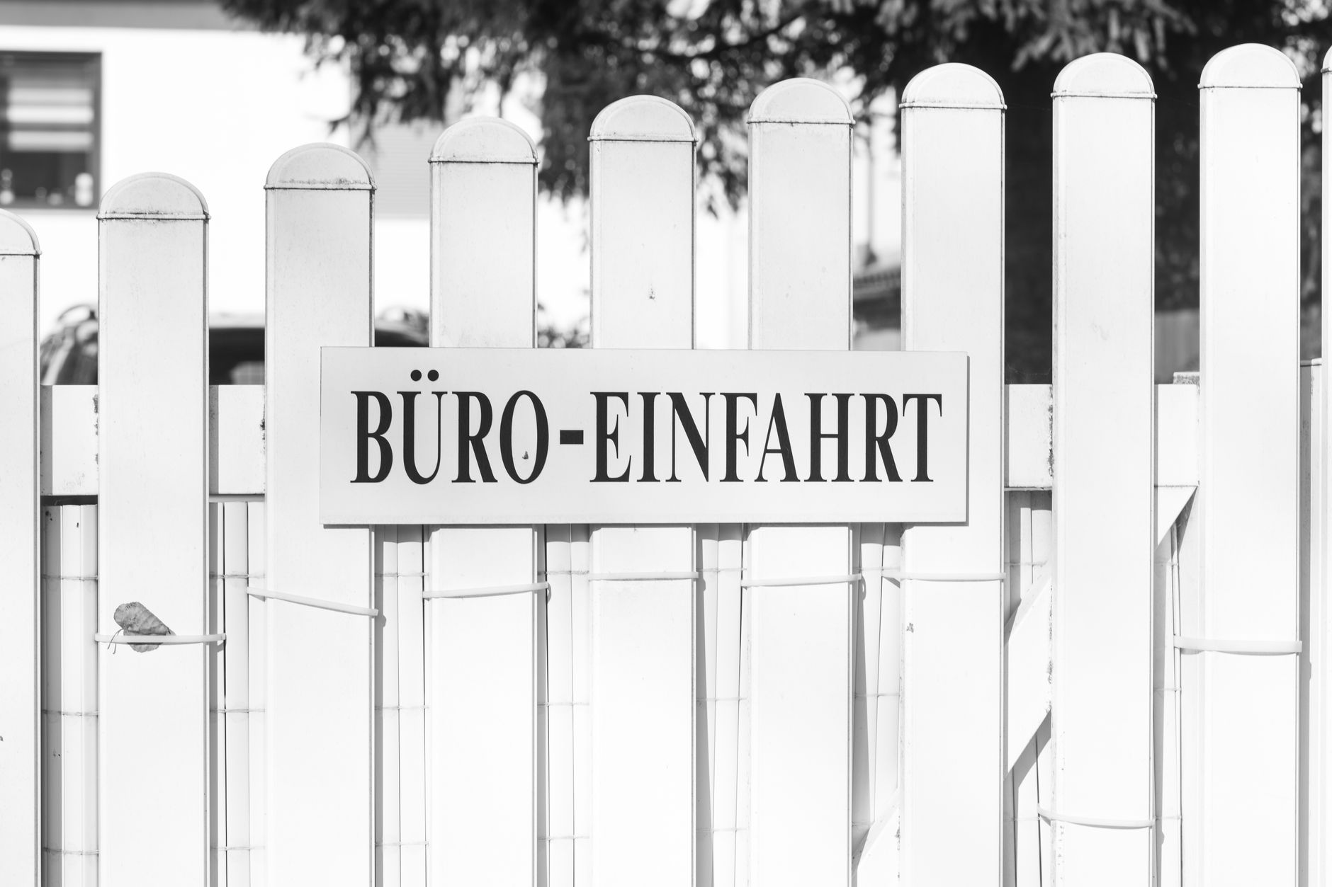 outdoor view of a large Army post installation entrance gate with a sign, flat Texas terrain and low buildings visible in the background