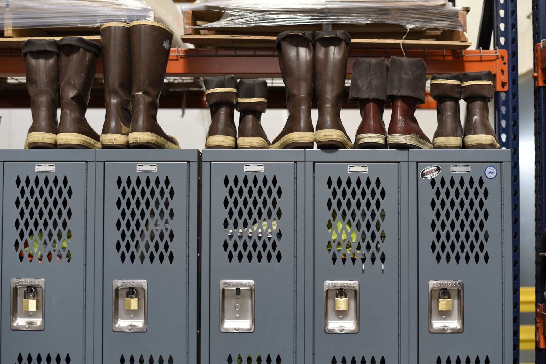rows of Arrow interceptor missile canisters in a secured outdoor storage area at a defense production facility, no personnel visible