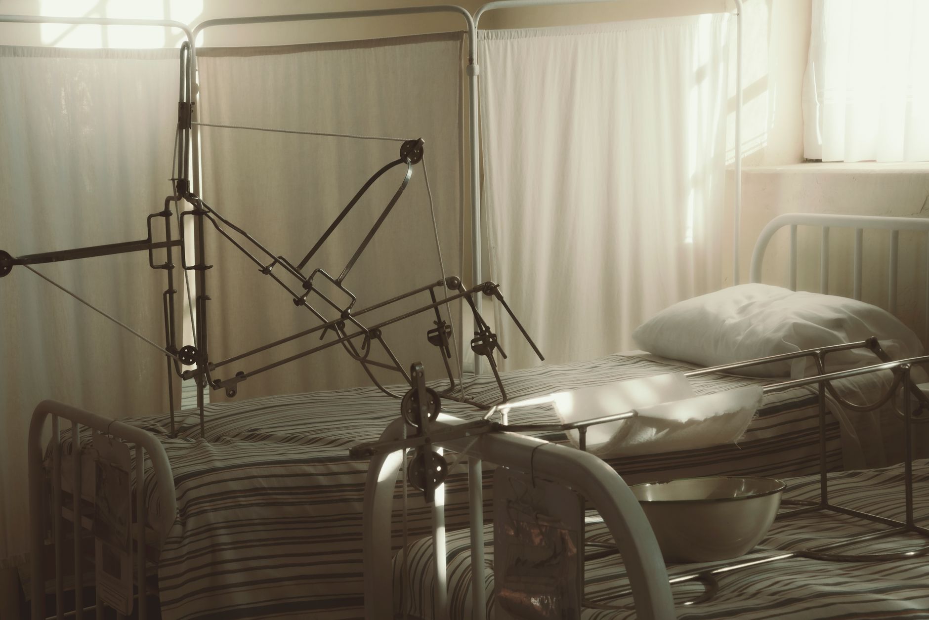 interior of a modern Israeli hospital ward with unoccupied beds, medical equipment, and large windows overlooking an urban skyline