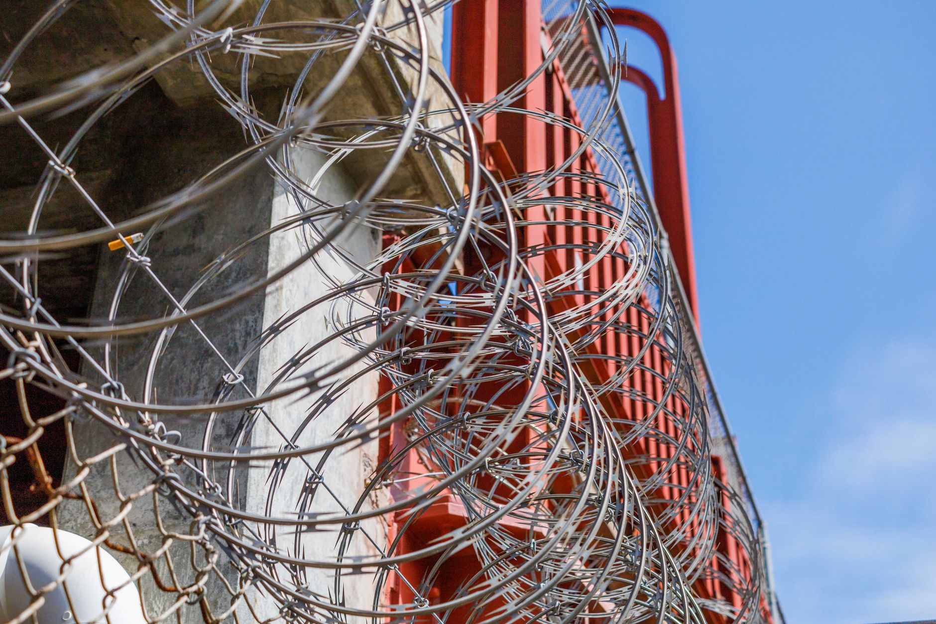 exterior of a defense propulsion manufacturing facility, industrial buildings and secured perimeter fencing in an arid landscape