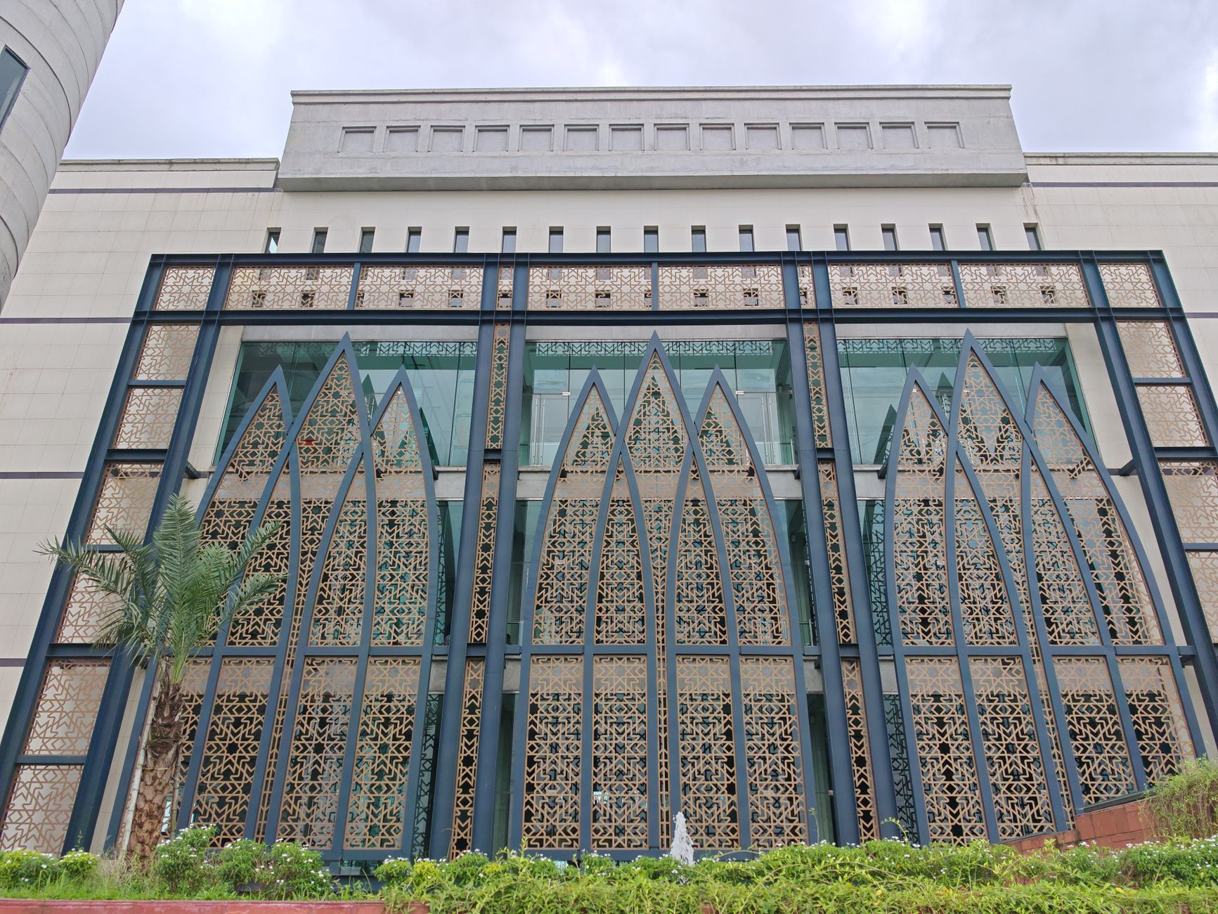 exterior of a modern Israeli technology and defense campus building, glass facade with a parking area and communications antenna array on the roofline, no people as focal point