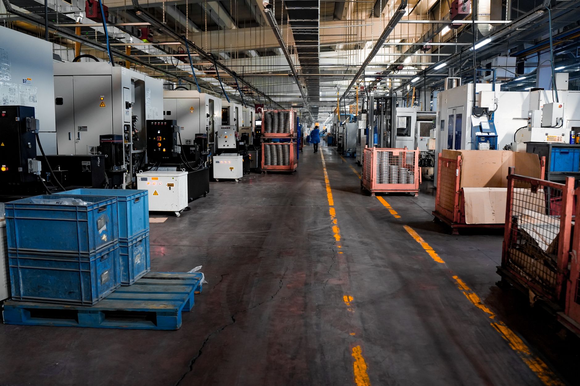 rows of missile interceptors inside a defense production facility, with overhead lighting illuminating launcher components on an assembly floor