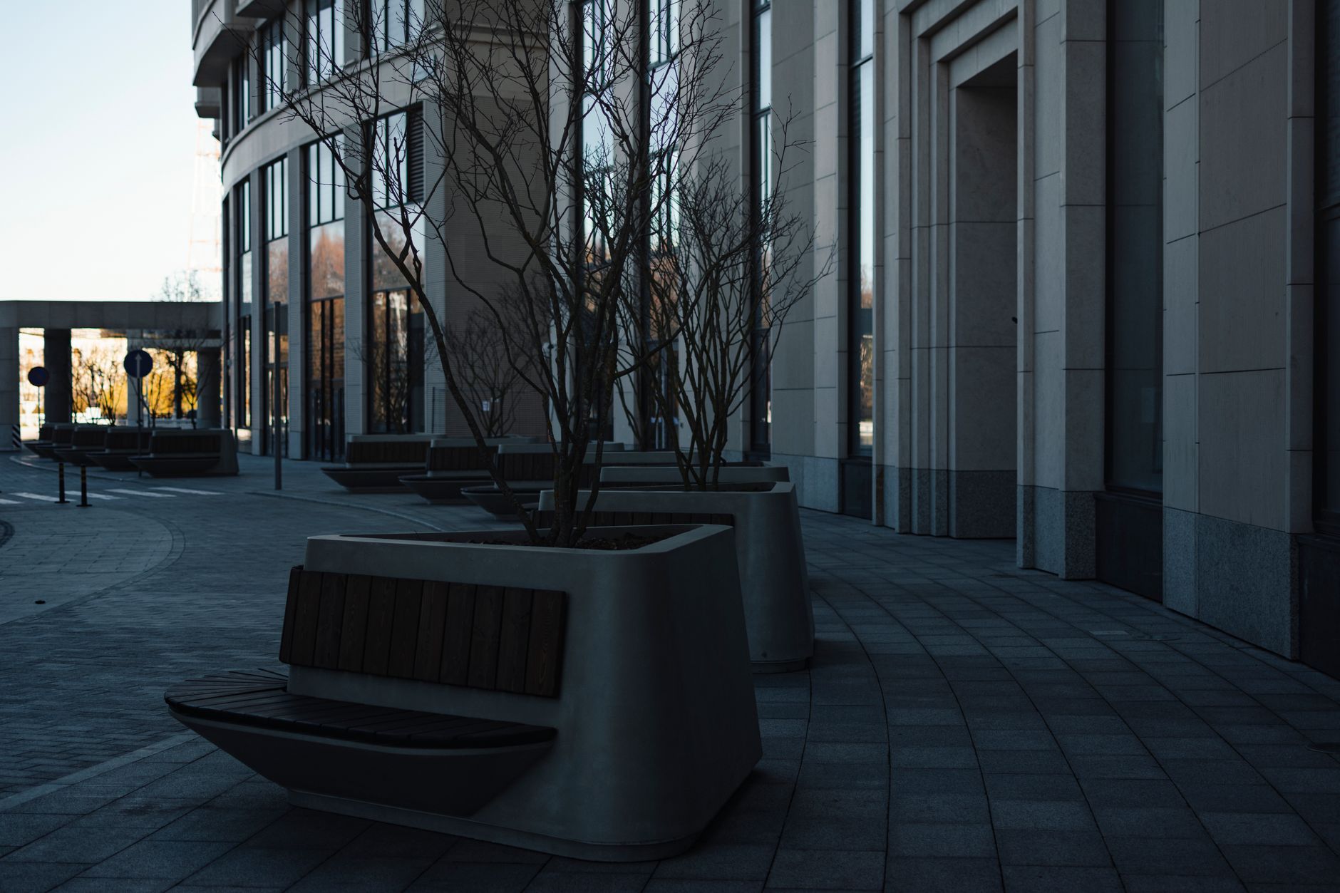 exterior of a mid-sized urban bank branch with a glass facade, empty sidewalk, signage visible from street level