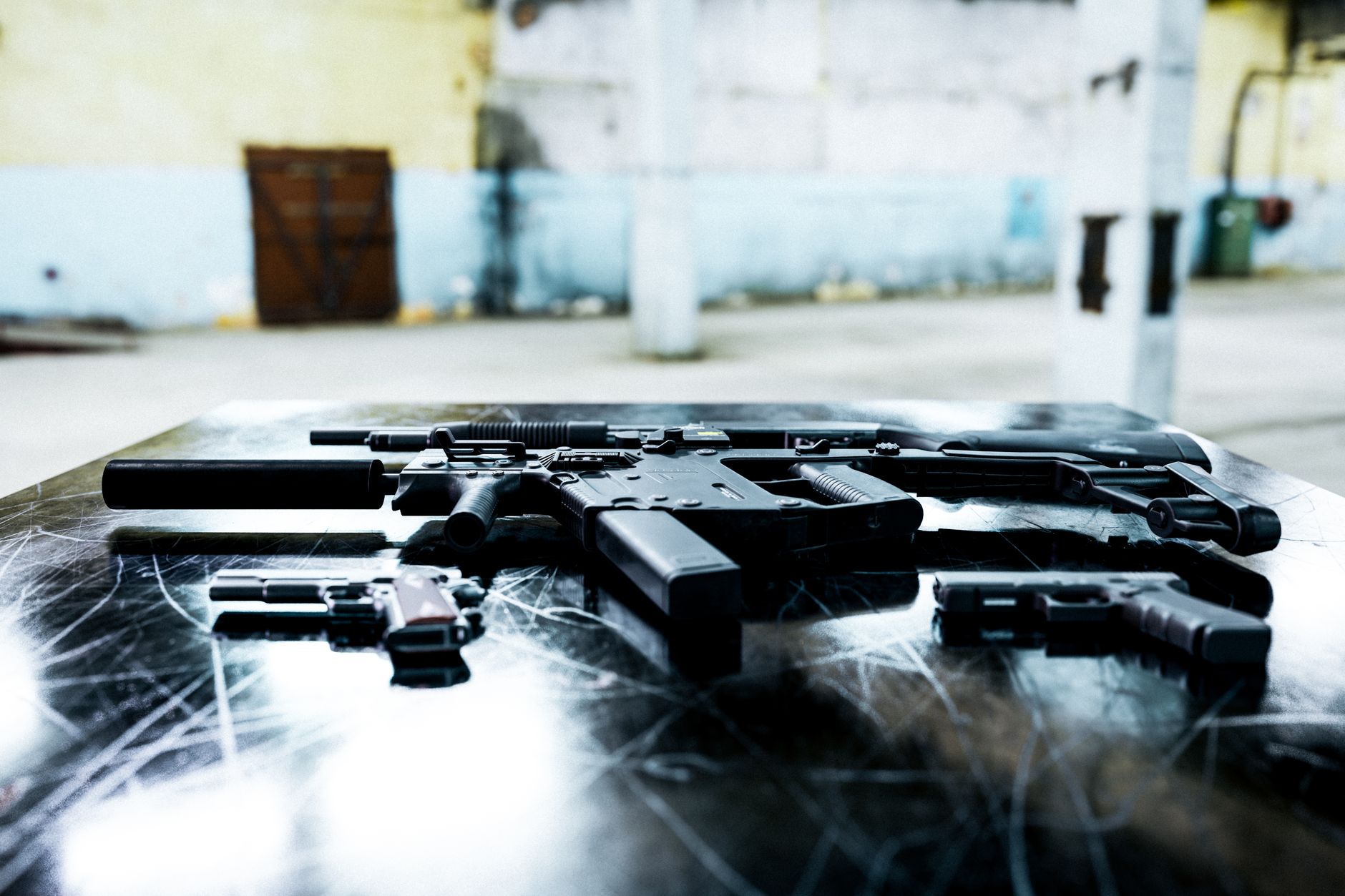 close-up of M27 Infantry Automatic Rifle resting on a table in a military equipment evaluation facility, with ammunition components arranged nearby