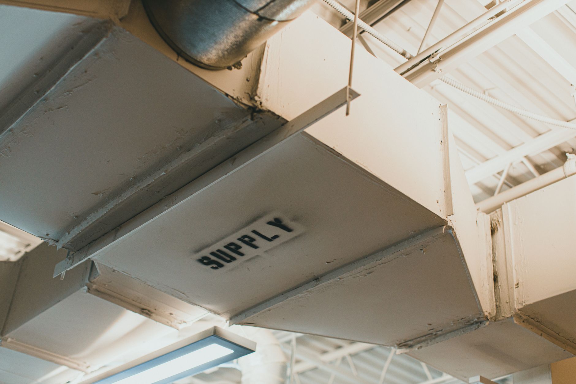 rows of air-to-air missiles in a climate-controlled weapons assembly facility, with metal shelving and industrial lighting visible throughout