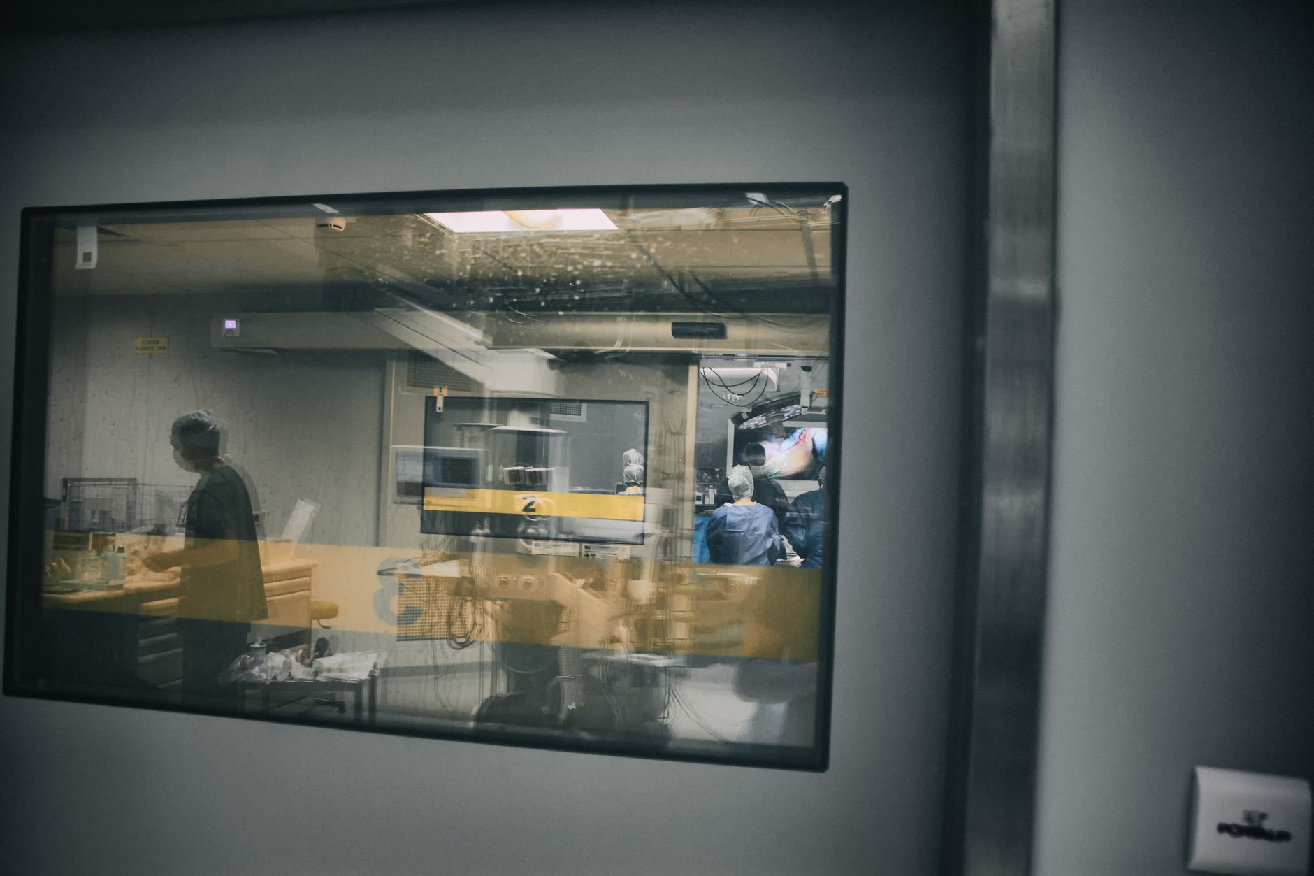 a U.S. Navy medical readiness operations center interior, with workstations, monitors displaying logistics data, and medical supply shelving along one wall
