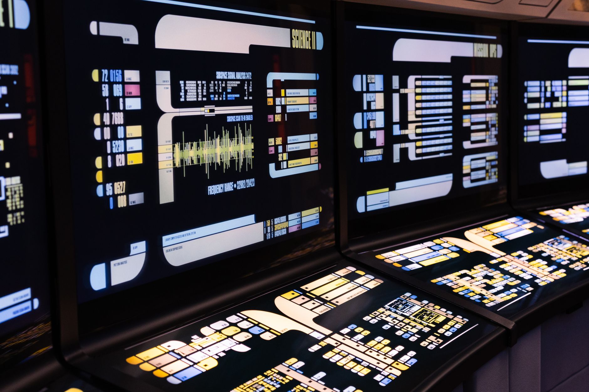 rows of counter-UAS command consoles inside a dimly lit operations center, screens displaying airspace tracking data and radar returns, no personnel as the focal point