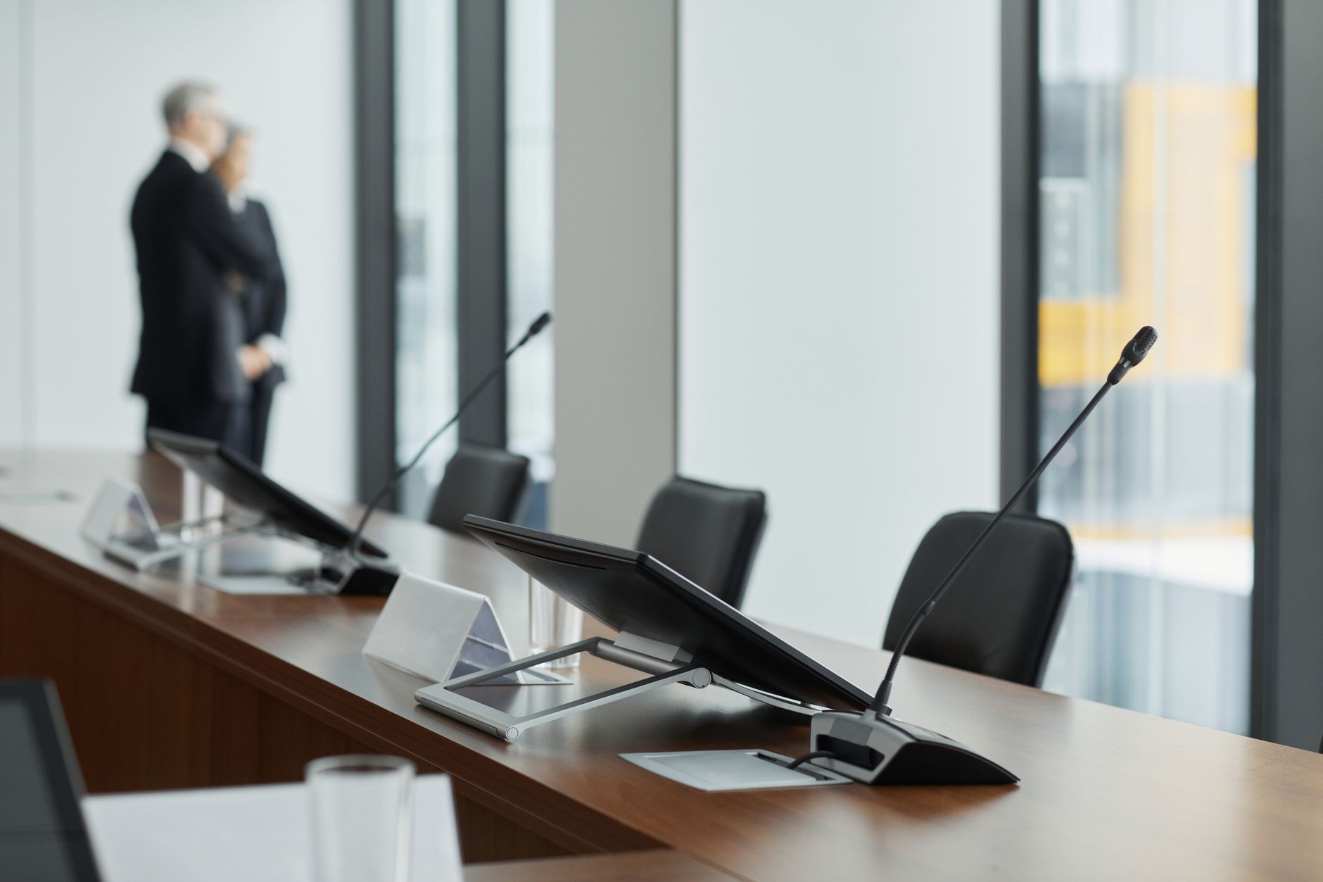 a large government conference room with digital display screens showing a vendor interface dashboard, no people as focal point, wide environmental shot