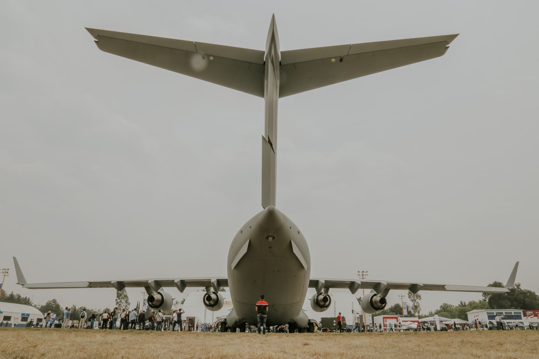a wide-angle view of a large U.S. military air base in Europe, with transport aircraft on the tarmac and support facilities visible in the background