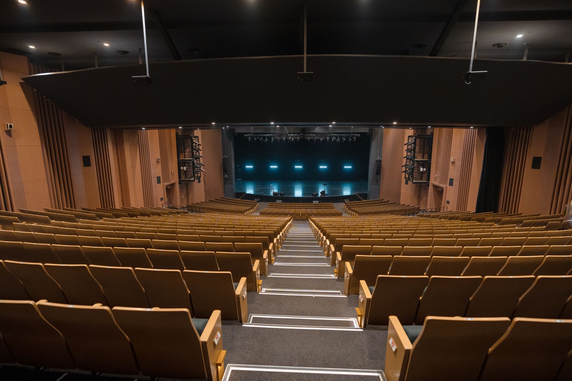interior of a Pentagon briefing room with projection screens and tiered seating, viewed from an elevated angle with no individuals as focal points