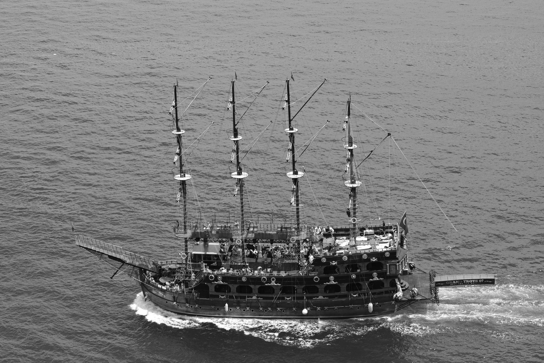 a naval frigate sailing through gray North Sea waters, viewed from the starboard quarter, with radar masts prominently visible against an overcast sky