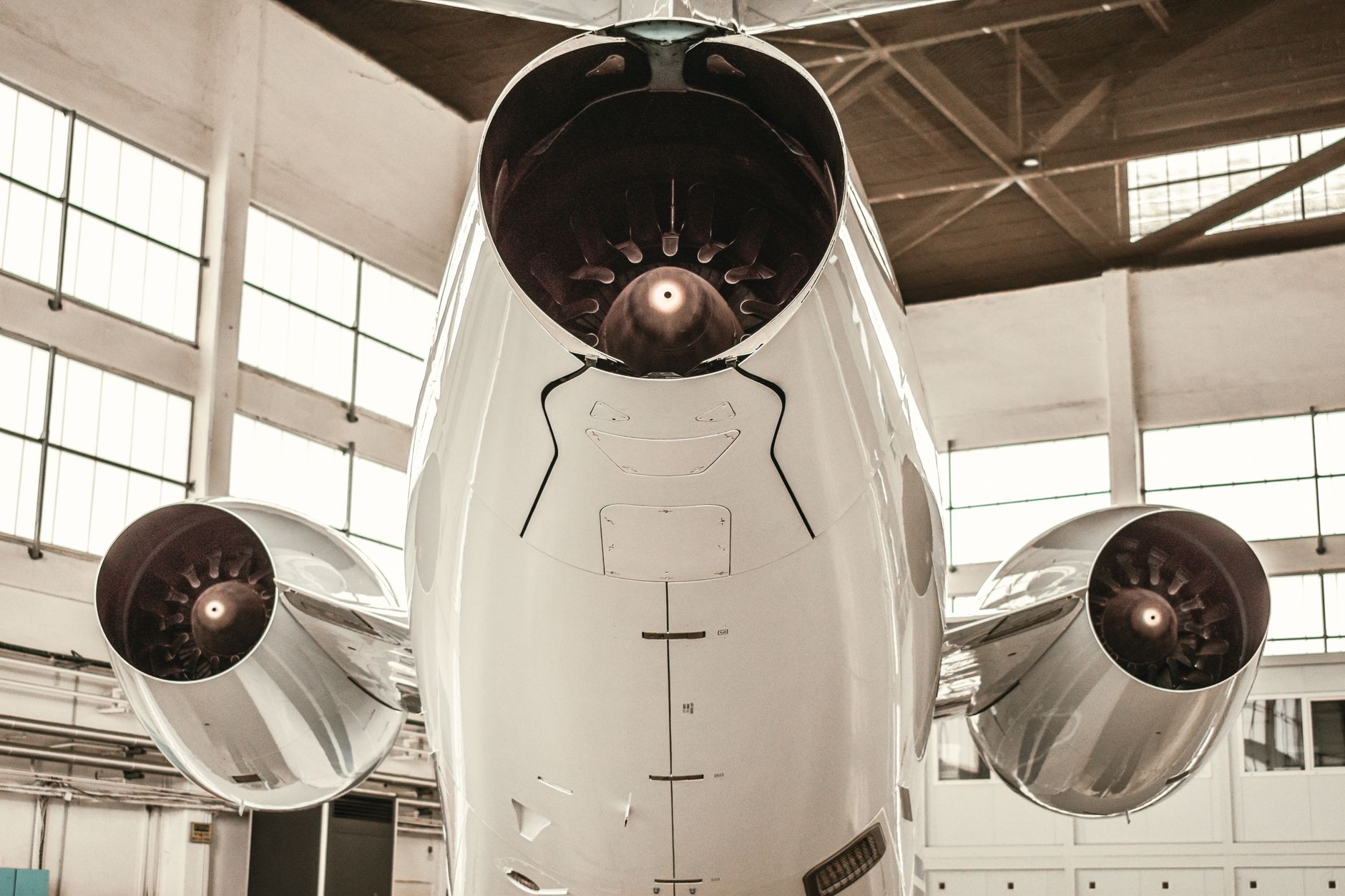 rows of small jet-propulsion test engines mounted on metal test stands inside a sparse industrial facility, with cables and measurement equipment visible in the background
