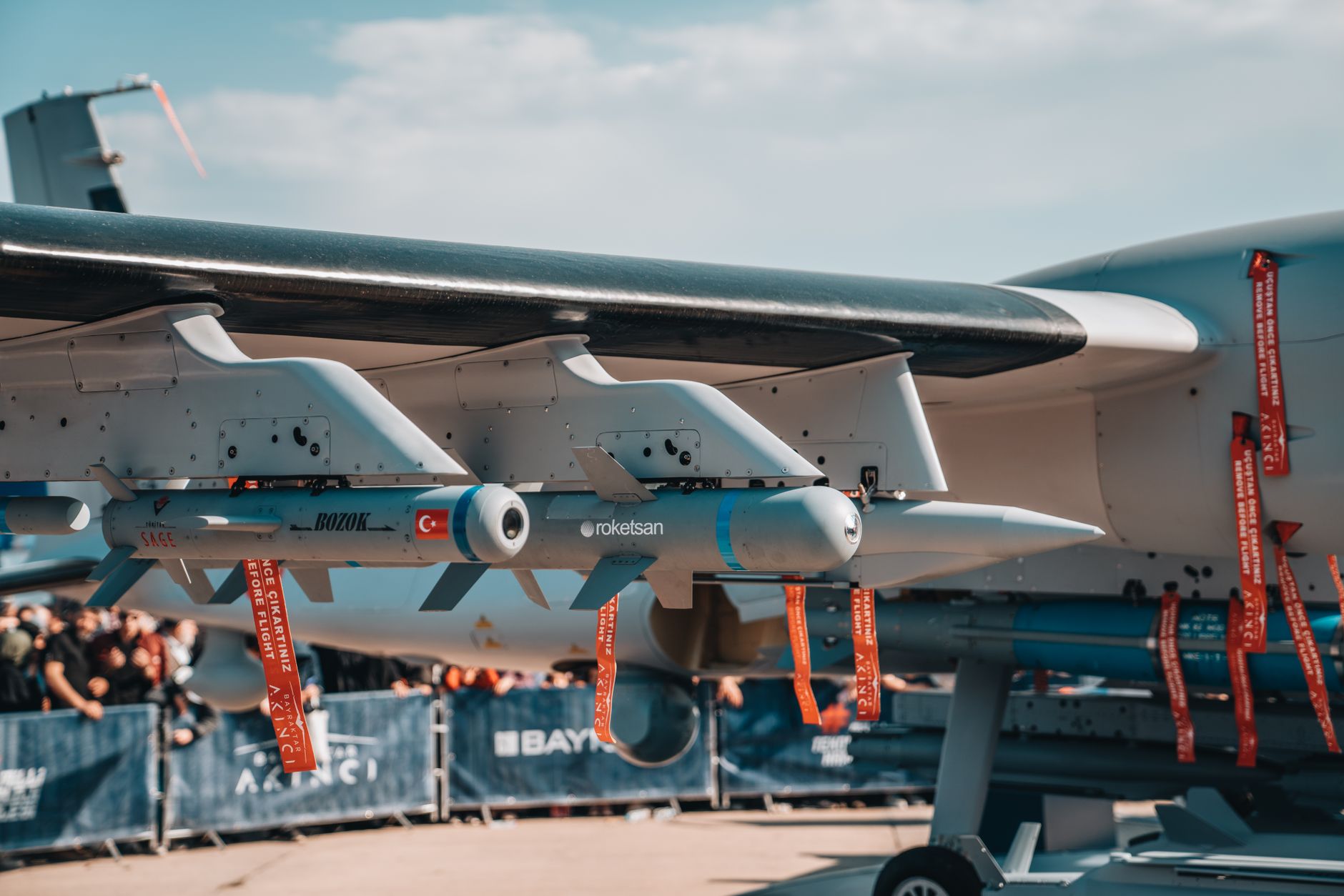 rows of cylindrical air-defense interceptor missiles on transport-erector launchers in an open storage yard, overcast sky overhead