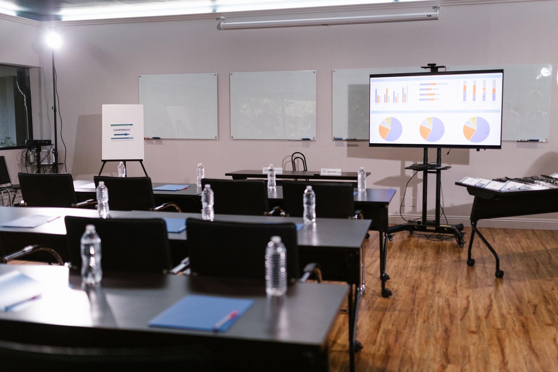 a large investment firm conference room with a long table, city skyline visible through floor-to-ceiling windows, chairs and presentation screens as focal elements
