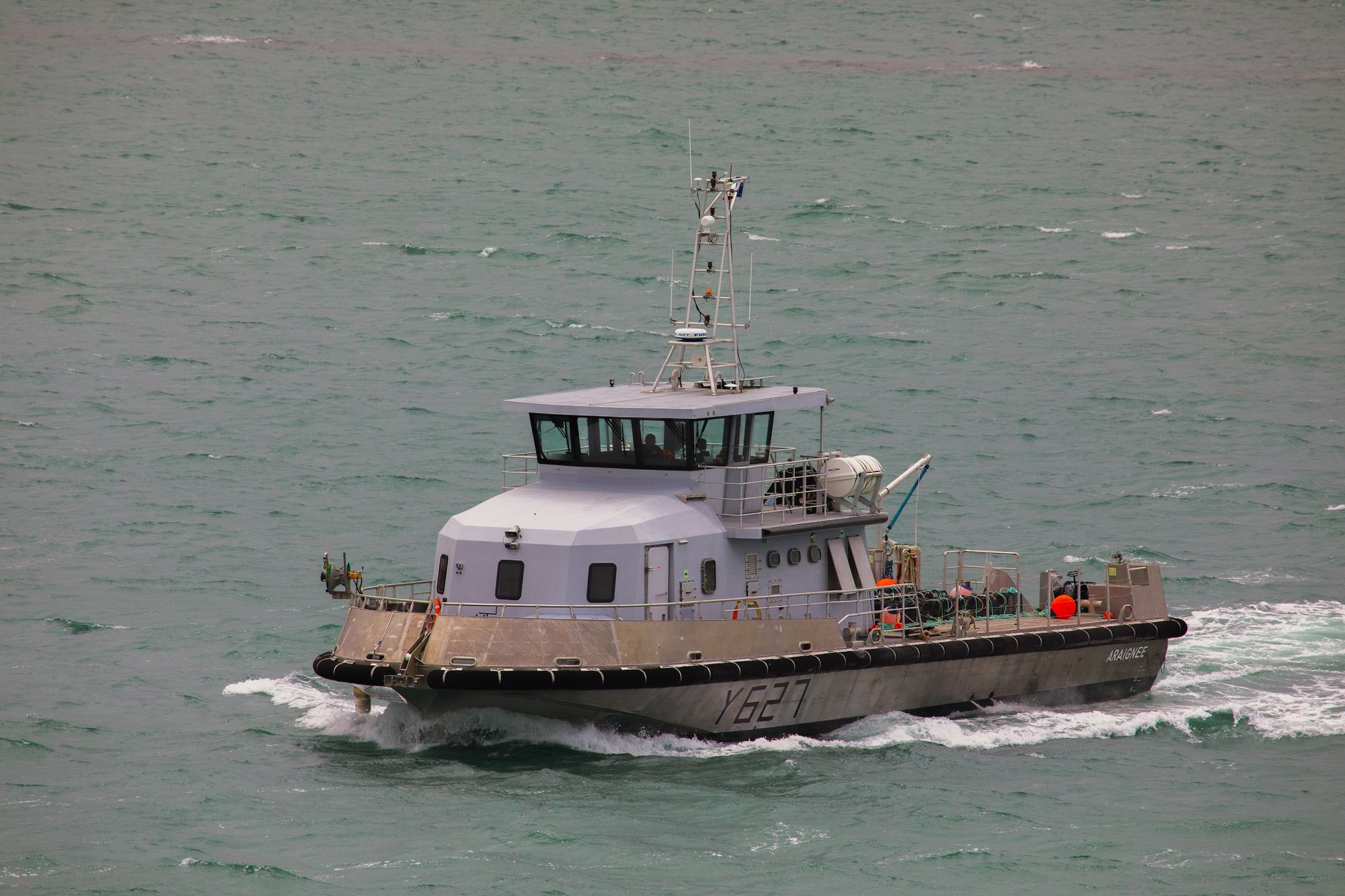 a U.S. Coast Guard cutter on patrol in blue Caribbean waters, with radar masts and communication equipment visible against an open horizon