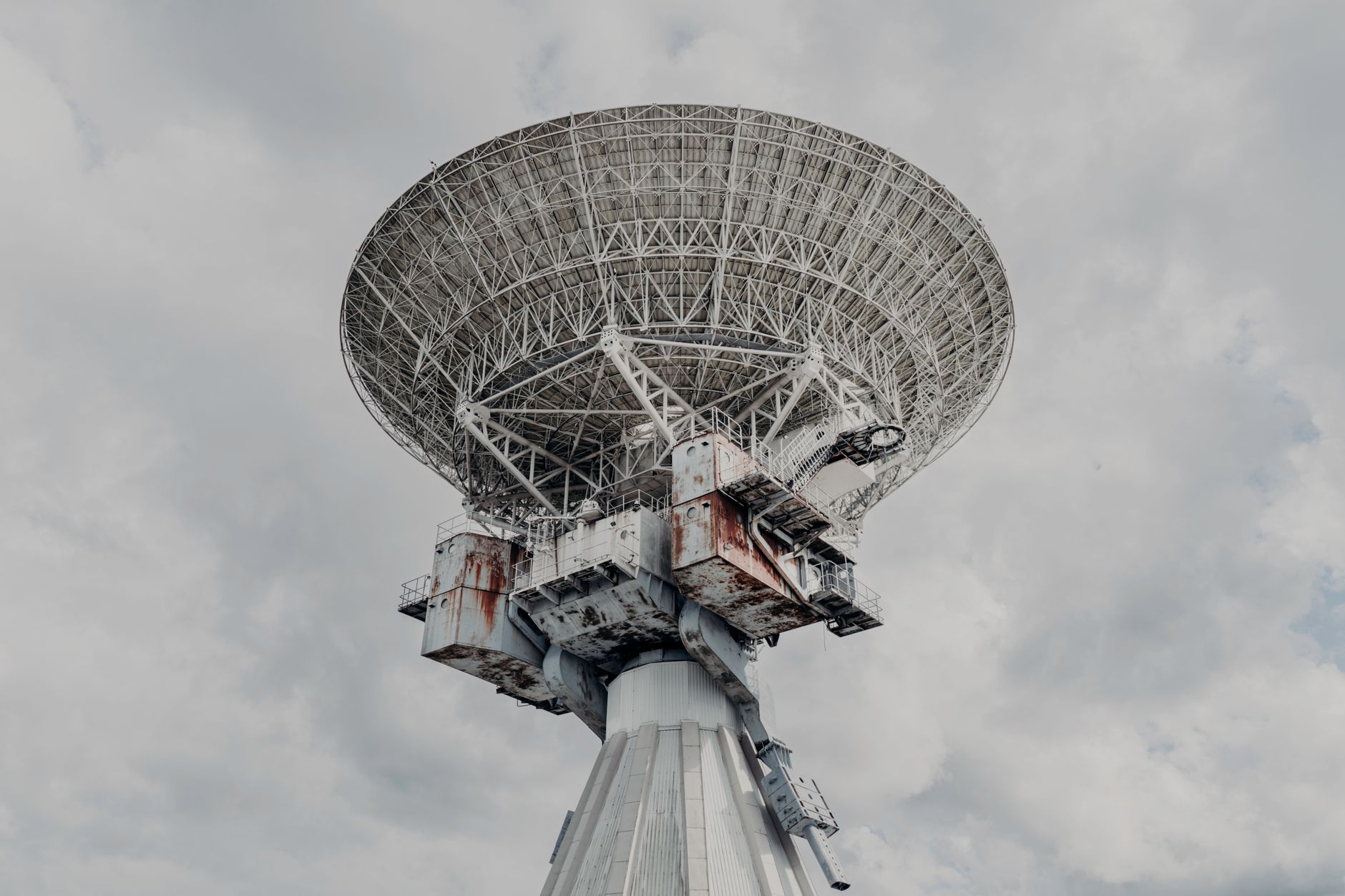 a satellite ground control station with large dish antennas in a remote desert landscape, no people visible, overcast sky