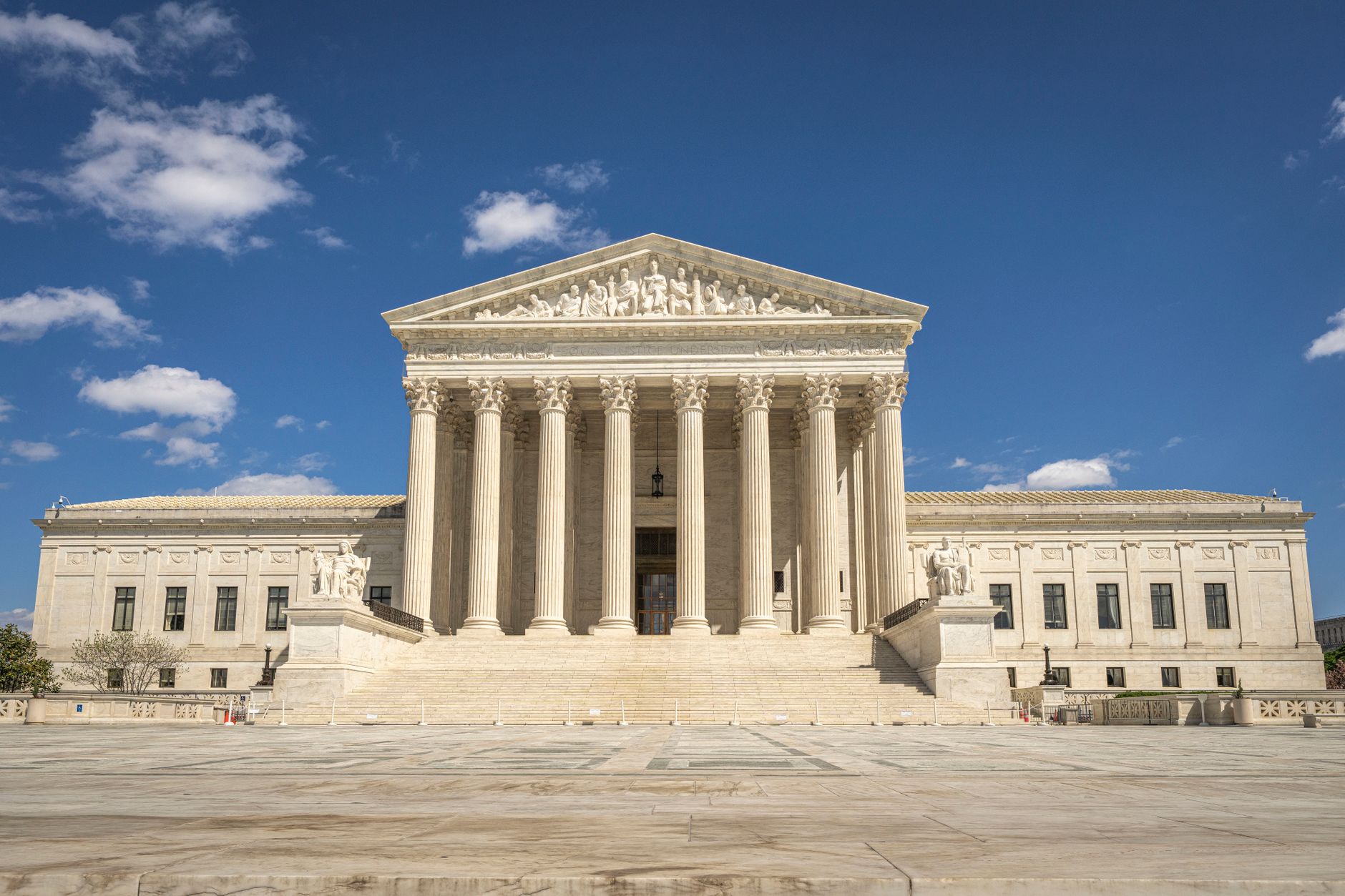 a federal courthouse exterior at night, stone columns and entrance steps lit by ambient streetlight, no people visible