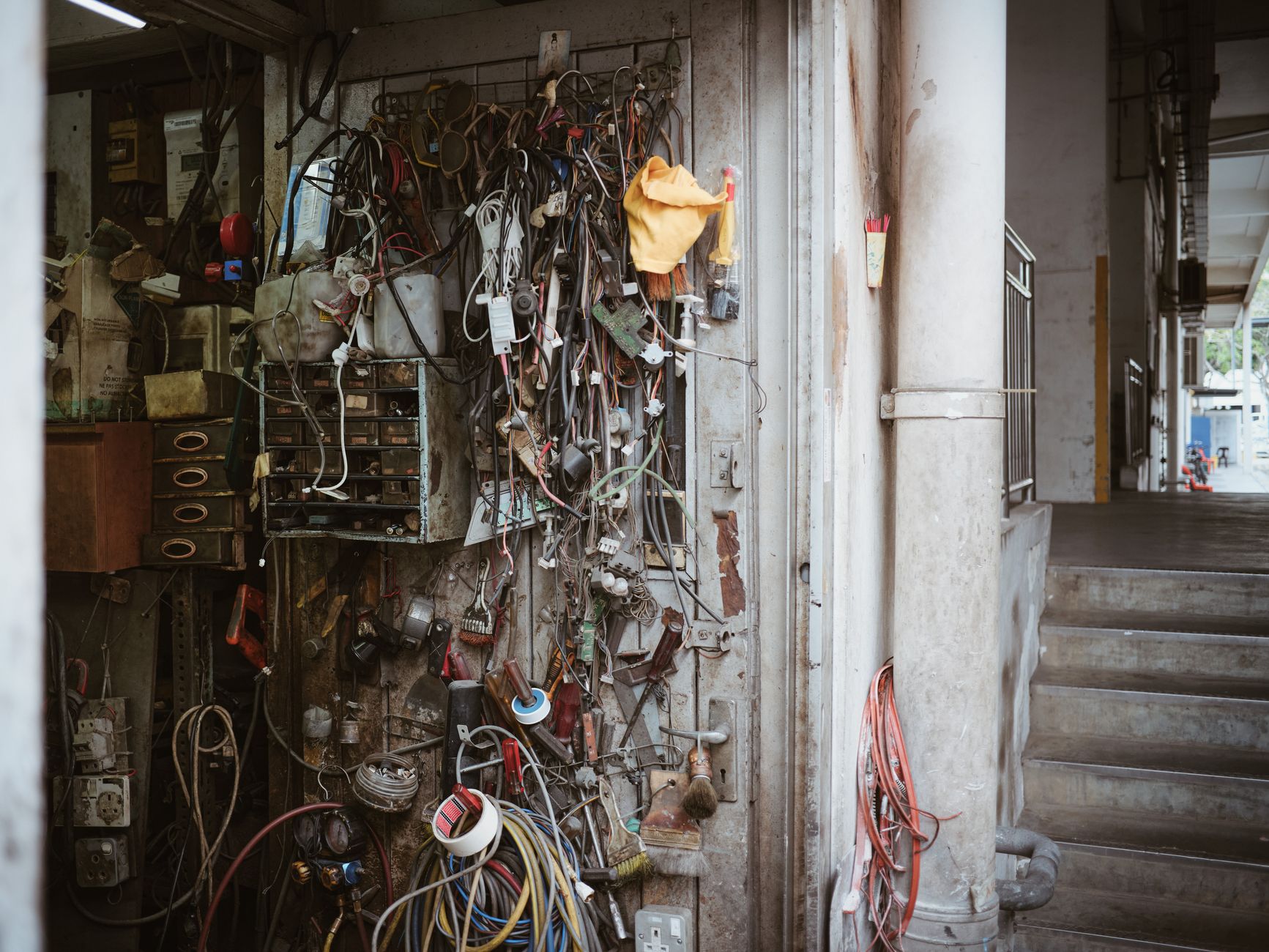 a workshop interior showing rows of small fixed-wing drone airframes on assembly benches, tools and wiring visible, industrial lighting overhead