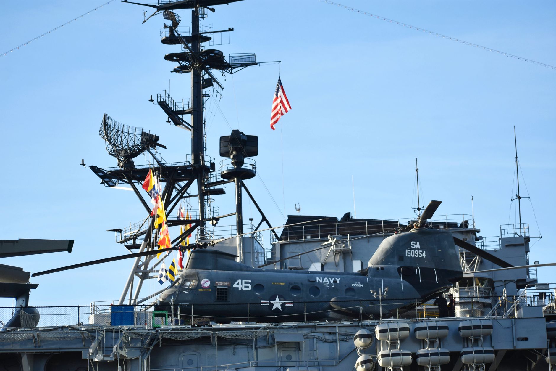 USS Abraham Lincoln aircraft carrier underway at sea, flight deck visible with aircraft spotted on the bow, horizon in background