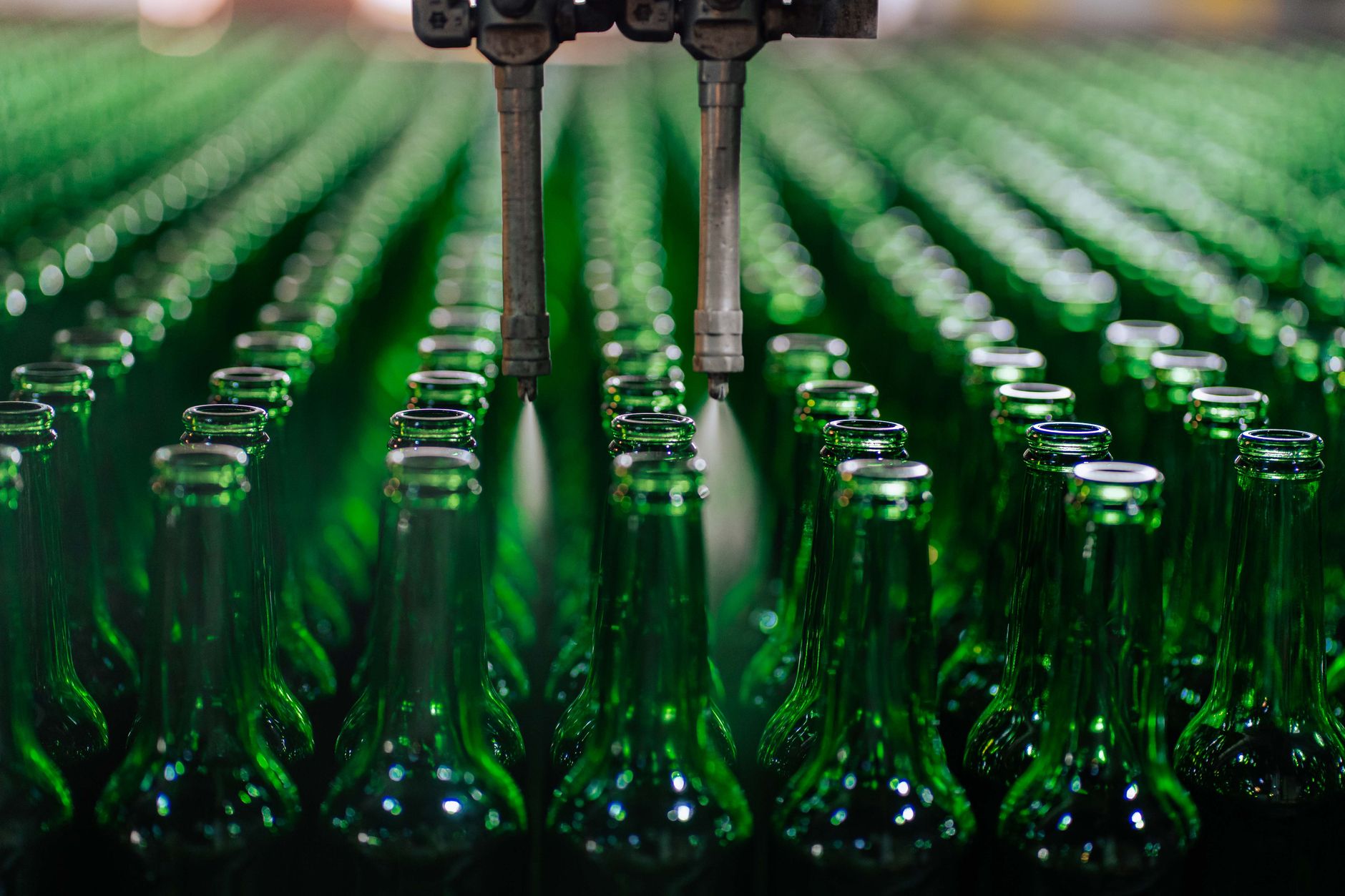 rows of robotic actuator assemblies on an automated production line inside a large factory facility, shot from a wide angle showing the full manufacturing floor