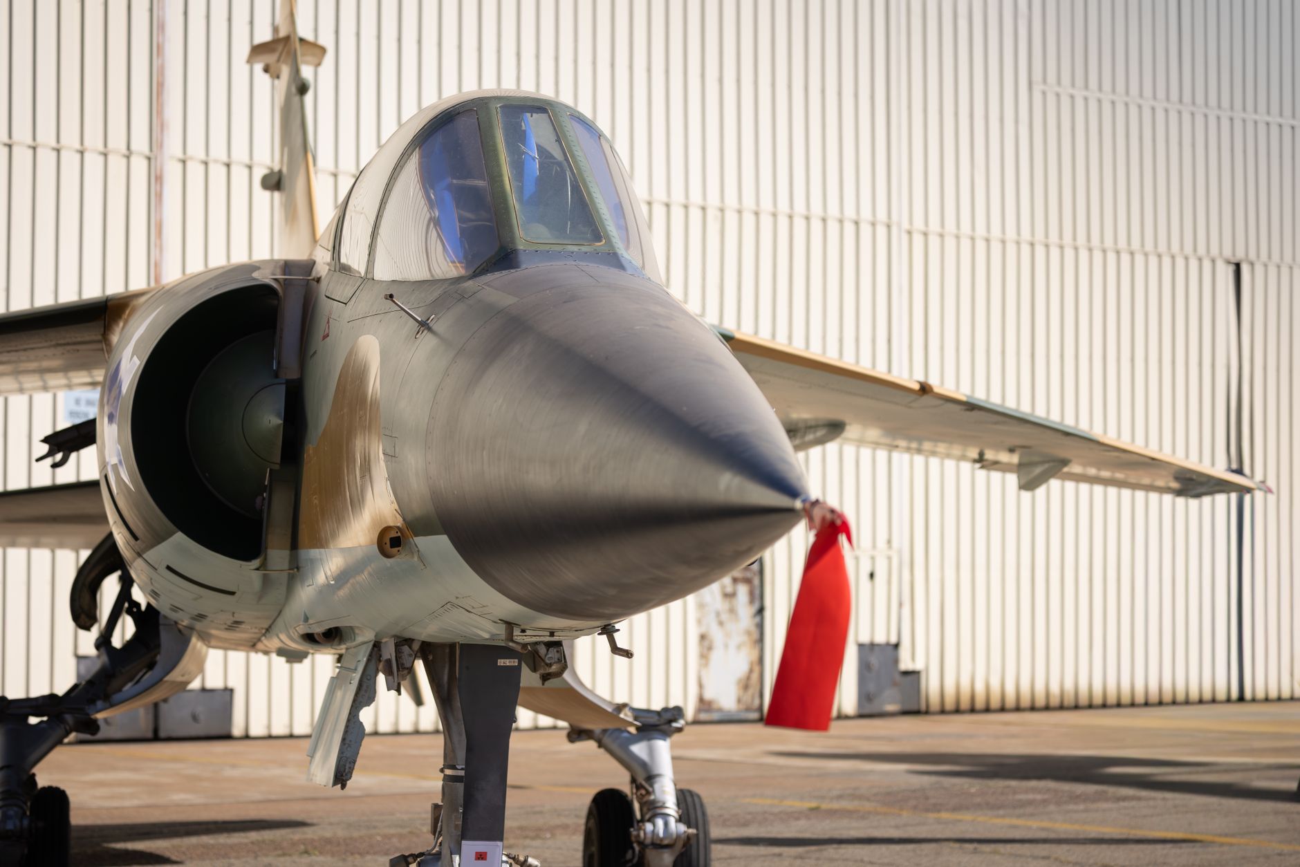 an X-62A VISTA experimental aircraft on a flight line at Edwards Air Force Base, viewed from a low angle against an open sky