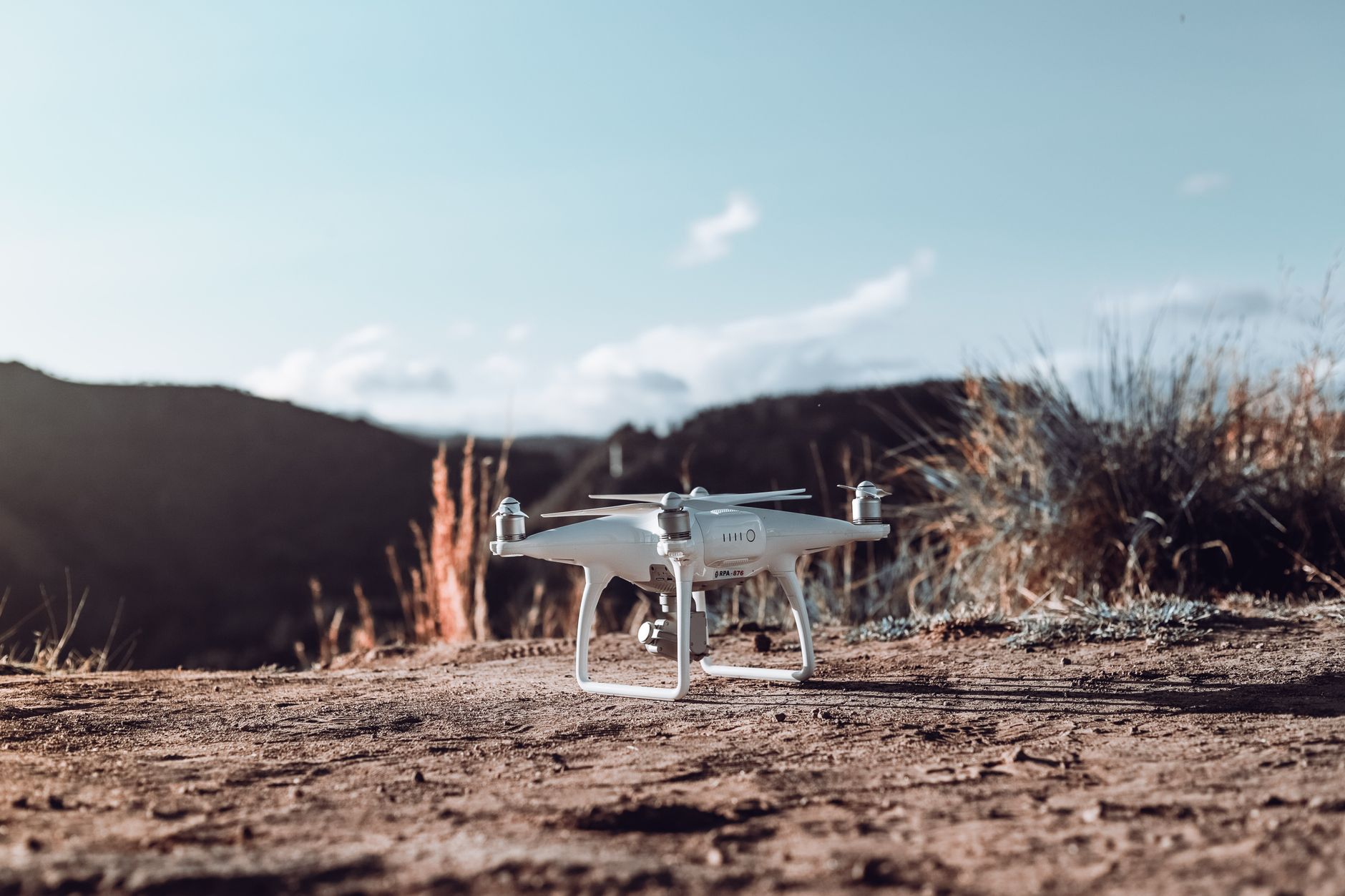 a compact autonomous drone system displayed on an outdoor testing platform, arid terrain in the background, no personnel visible