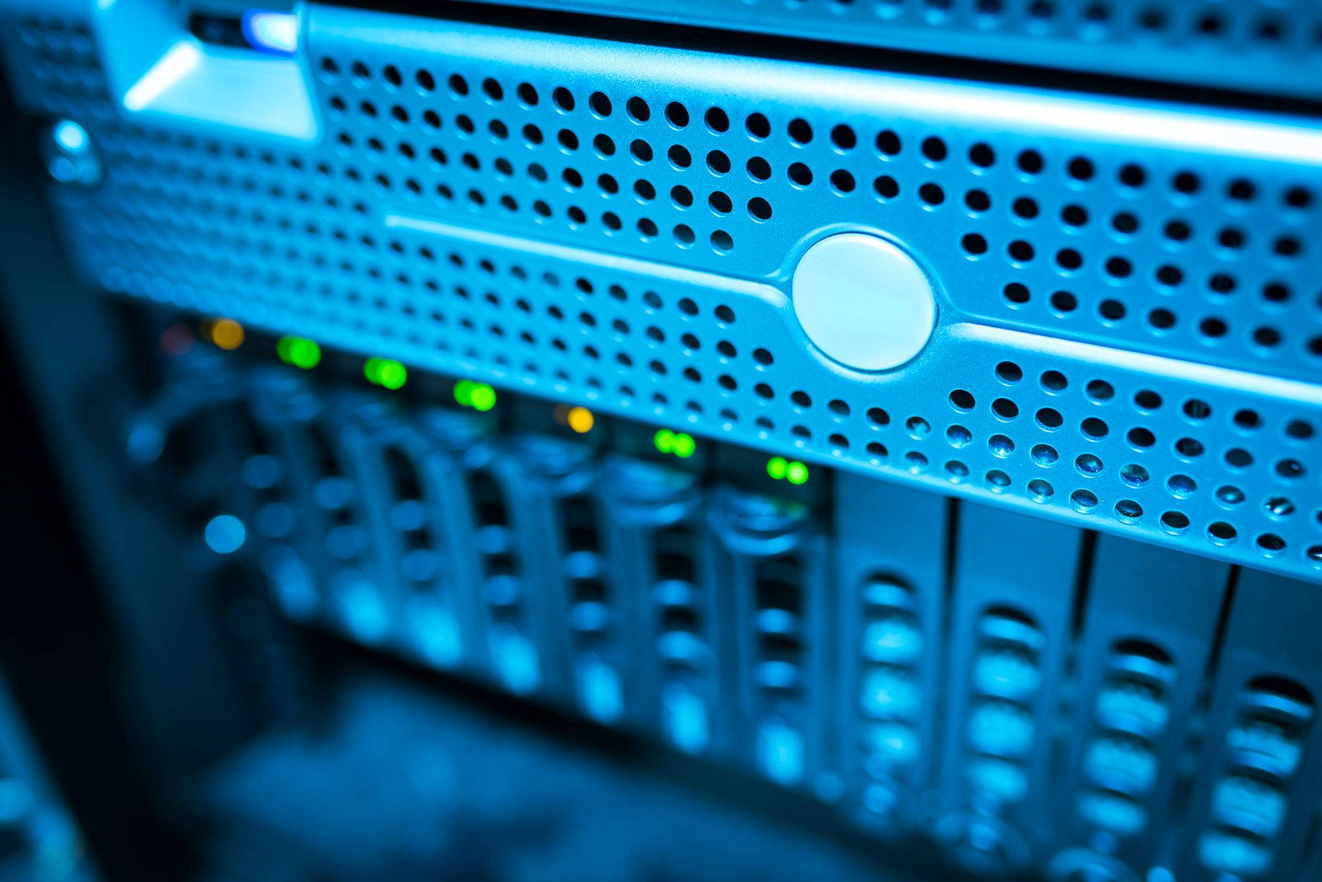 a data center server room with dense rows of illuminated rack-mounted servers and blinking network hardware, viewed from a wide aisle angle