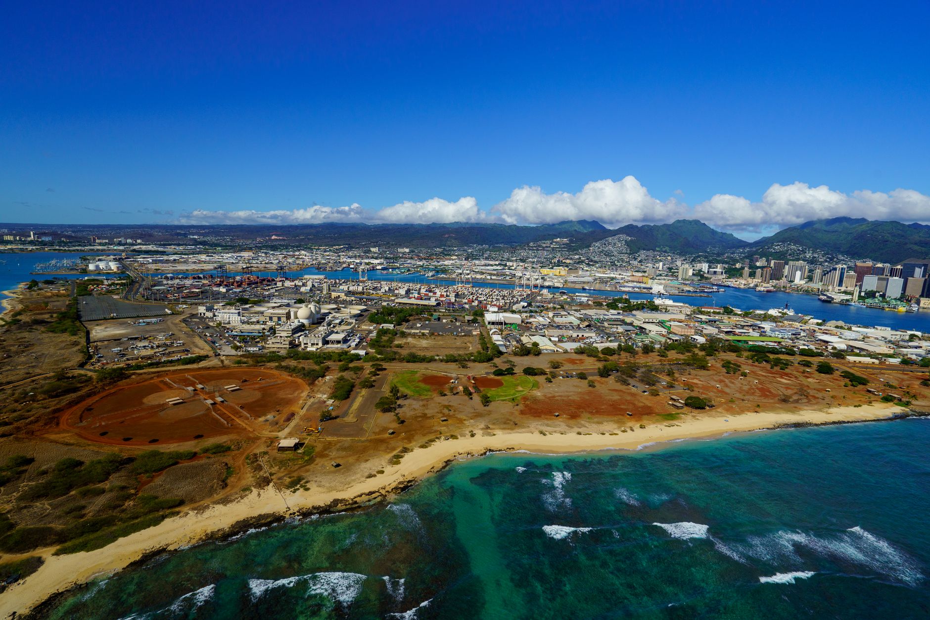 an aerial view of a large U.S. air base on a Pacific island, showing runways, taxiways, and dispersed support structures
